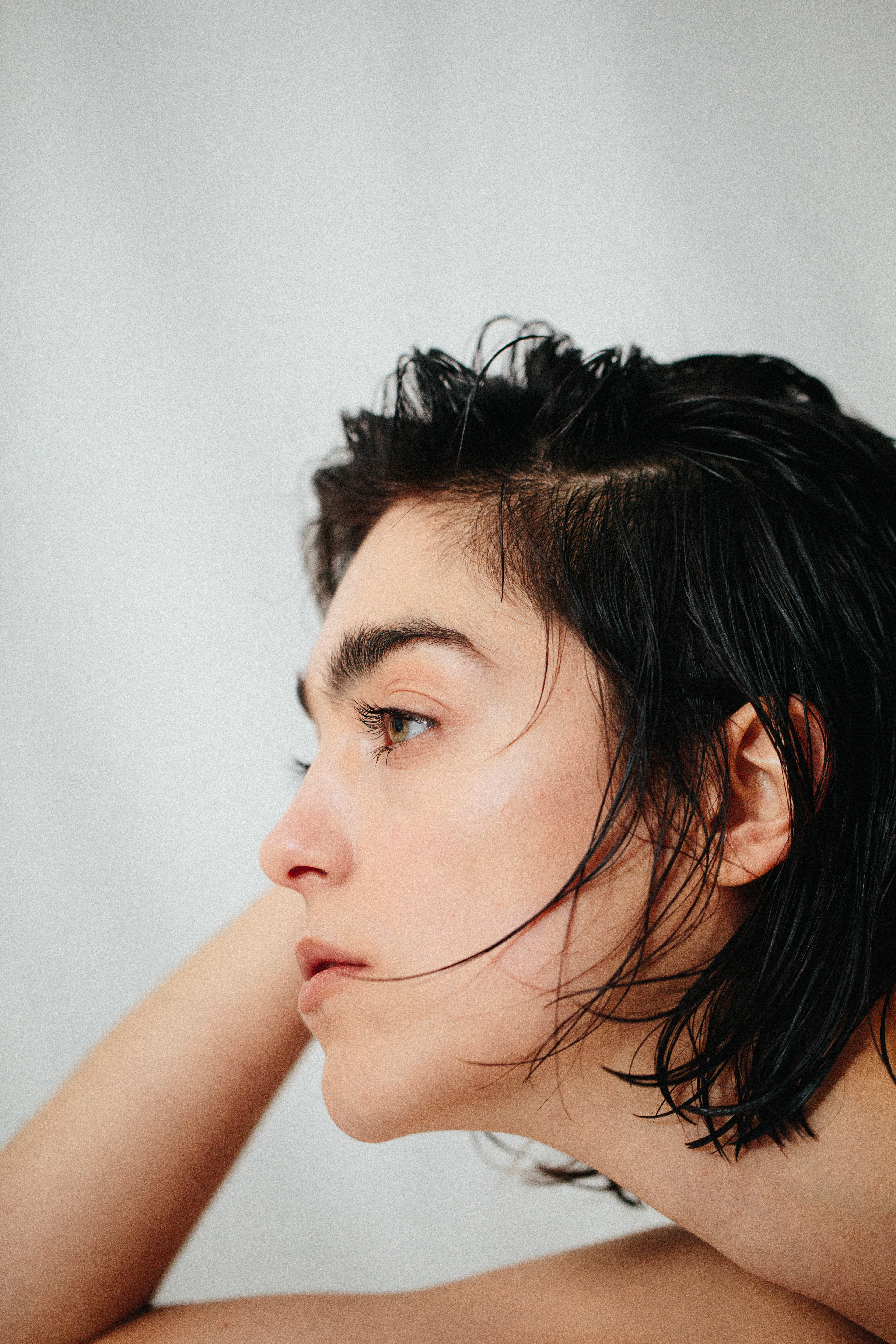 Porträtaufnahme von Jacqueline vor weißem Hintergrund mit ausdrucksstarkem Blick.