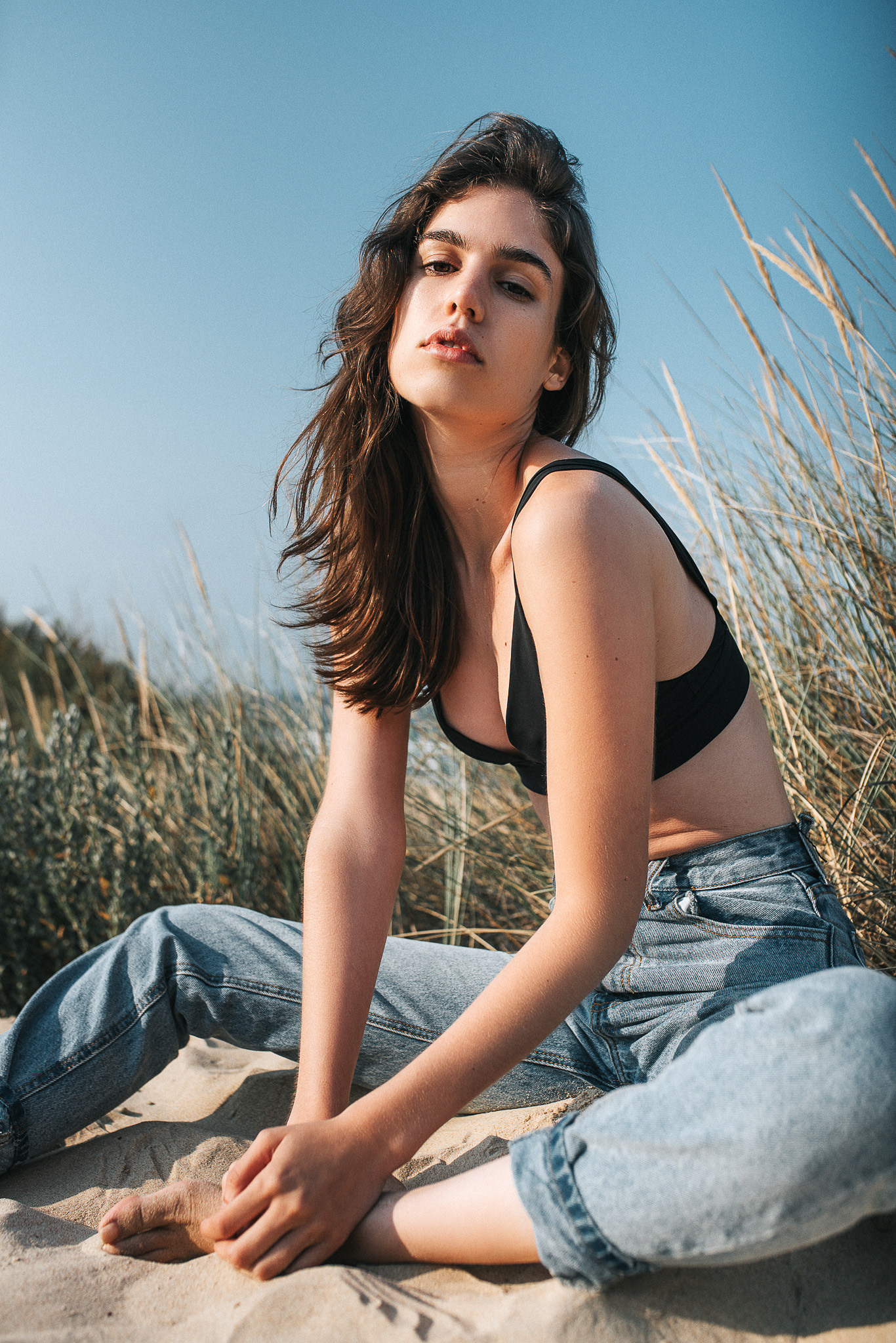 Model Helena im Wind – wehendes Haar und sommerliche Atmosphäre am Strand.