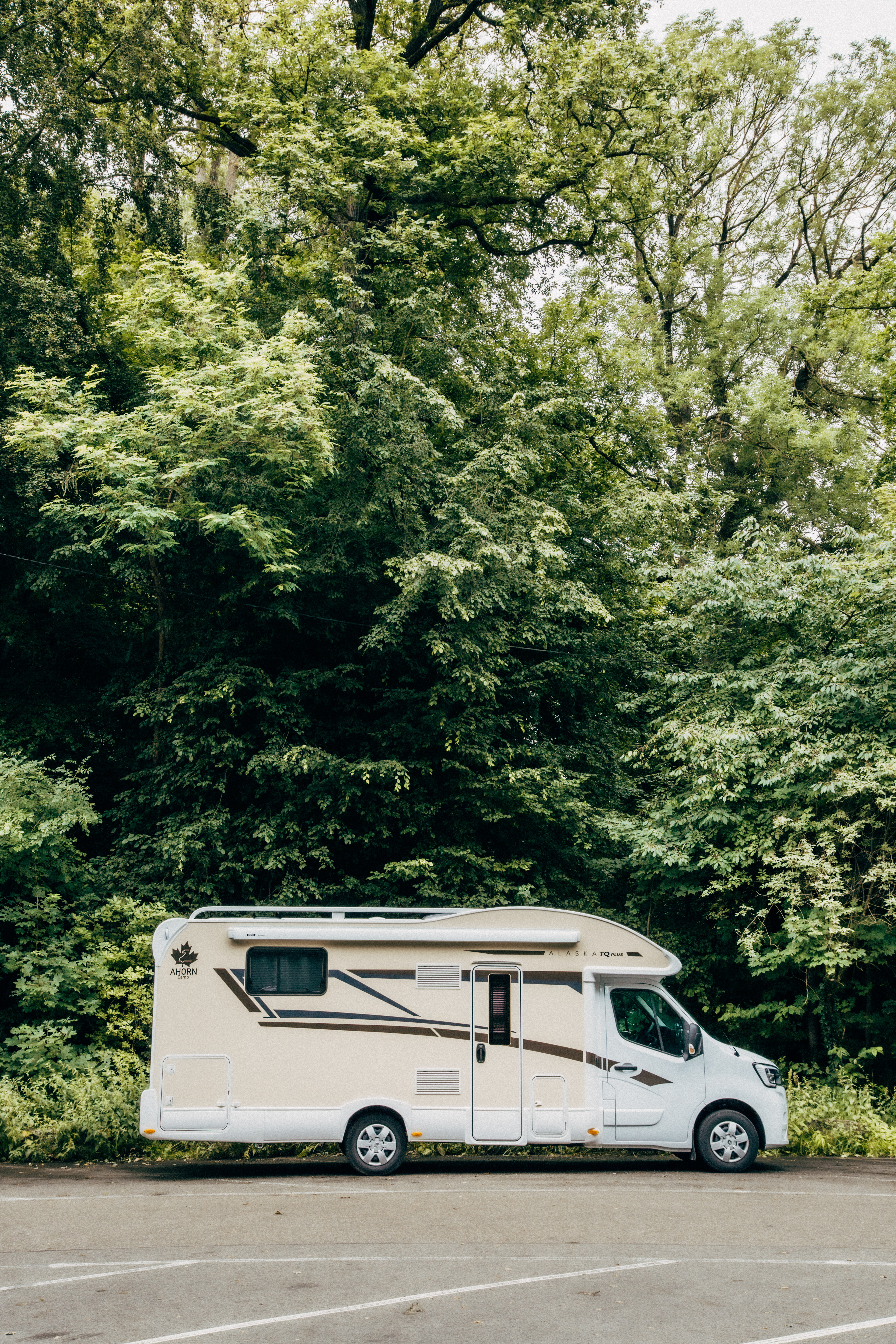 Ein Ahorn Camp Wohnmobil fährt eine schmale Straße durch die Weinberge von Stuttgart entlang.