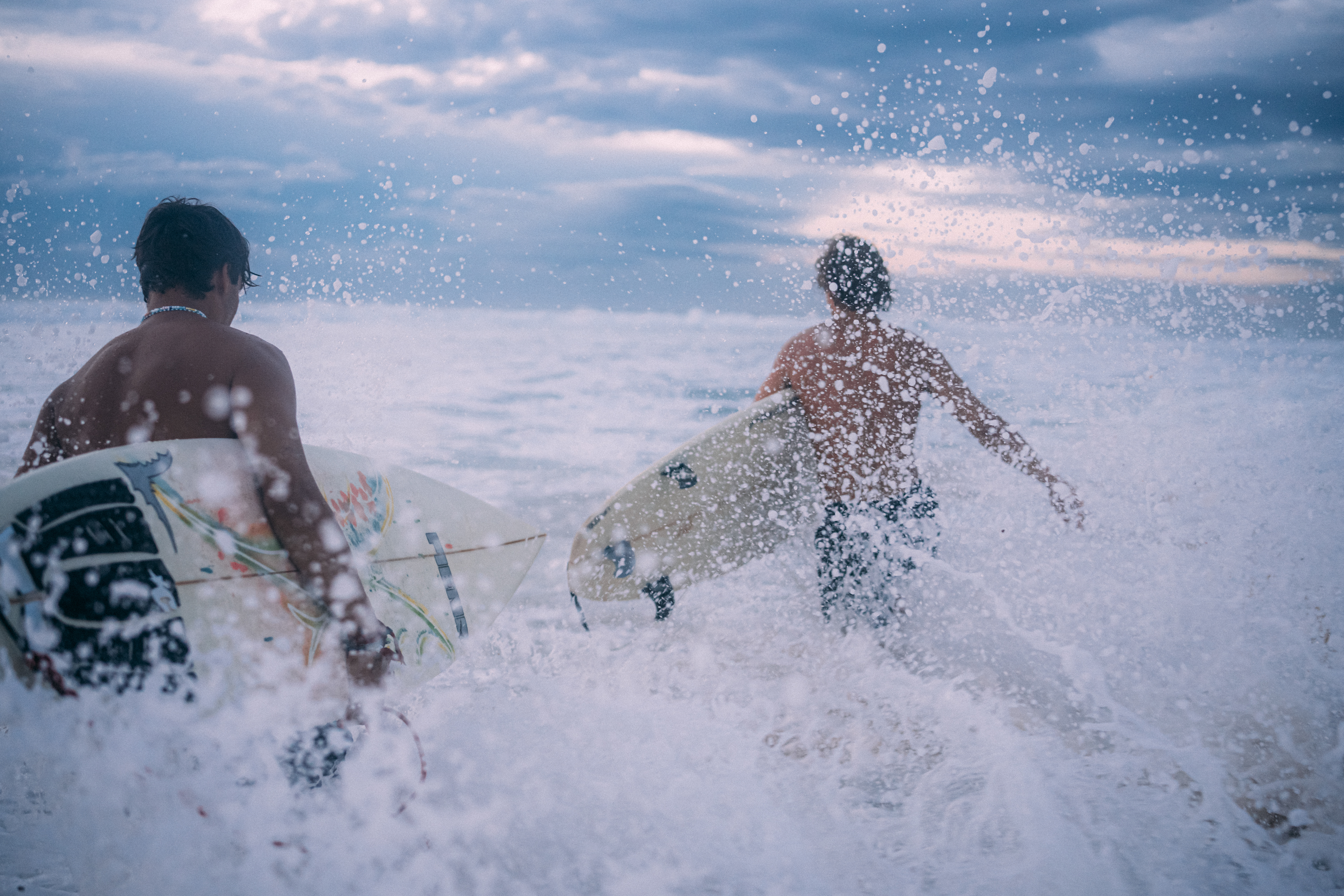 Magische Surf-Session – ein Surfer reitet eine Welle im sanften Licht der Dämmerung.