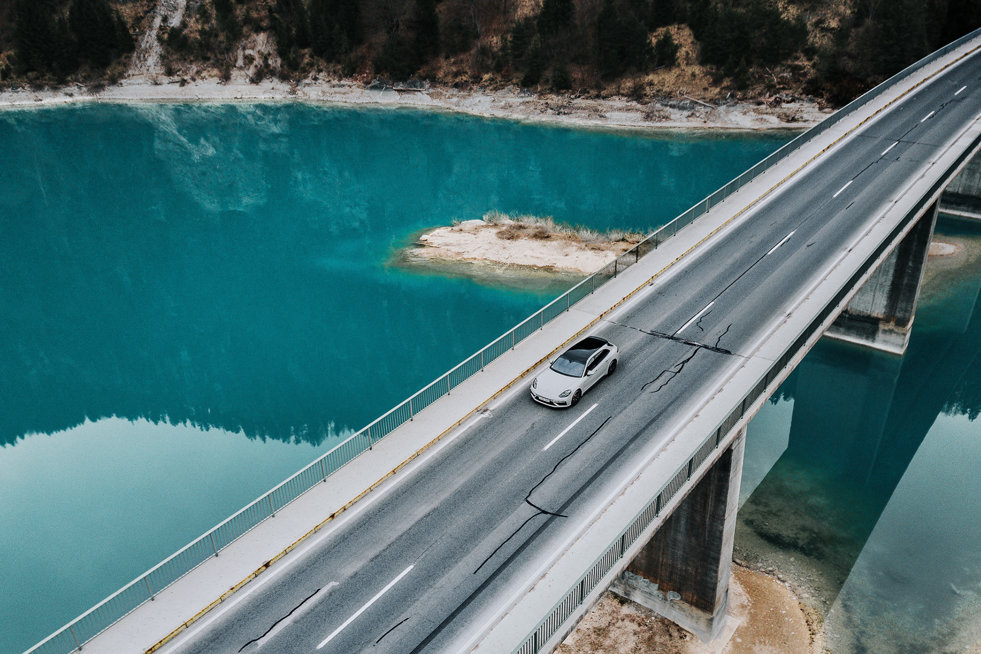 Sportlicher Porsche Panamera von oben fotografiert, während er durch eine malerische Landschaft fährt.