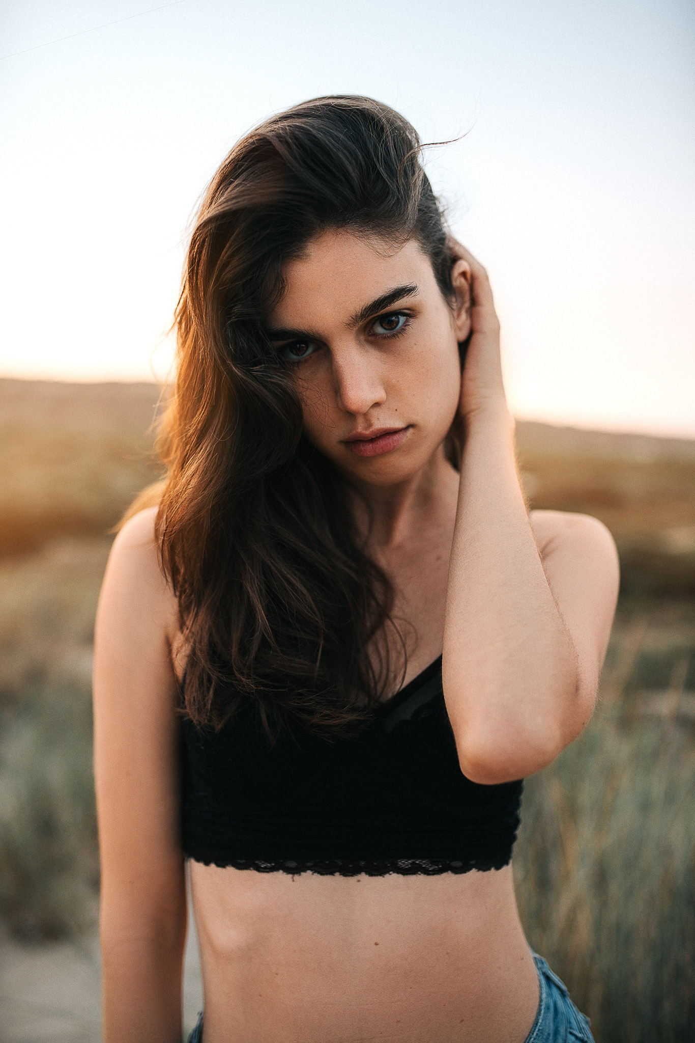 Model am Strand mit wehenden Haaren – Sommerstimmung und natürliche Eleganz.