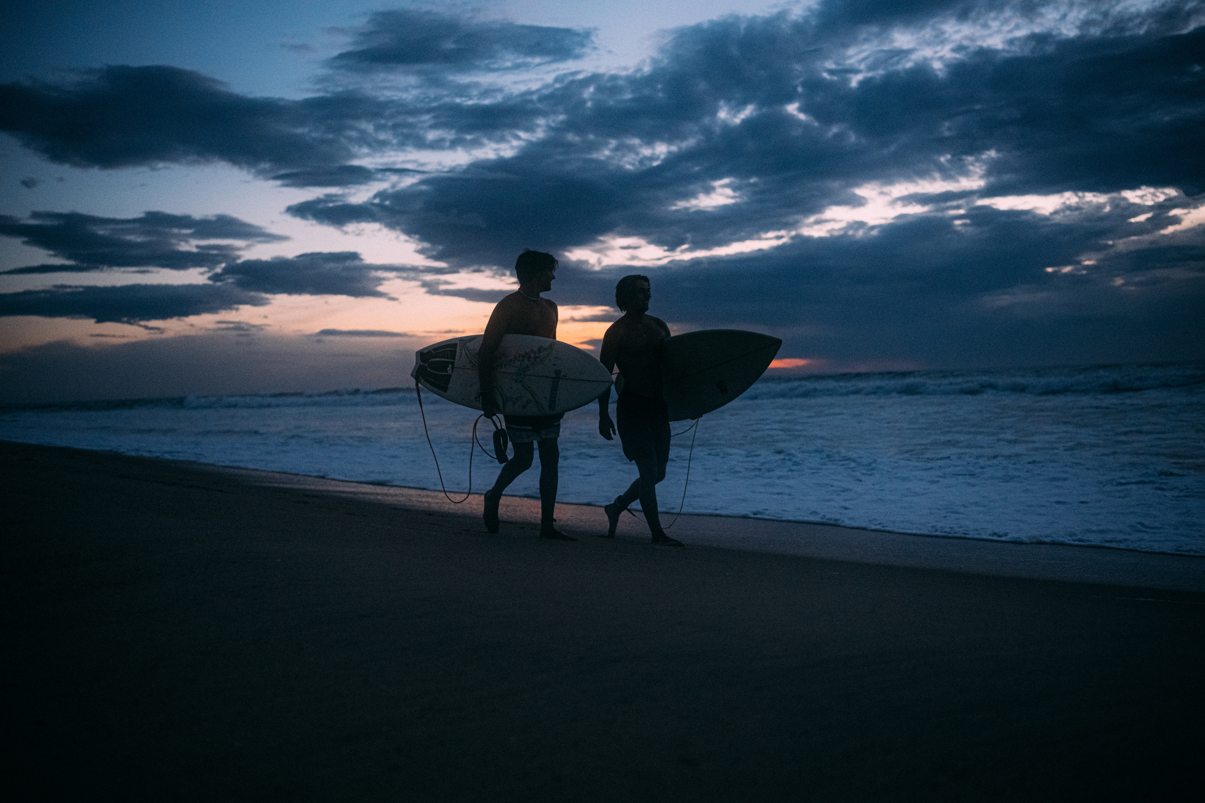 urfer gleitet mit ruhiger Eleganz über das dunkler werdende Meer in der Blauen Stunde