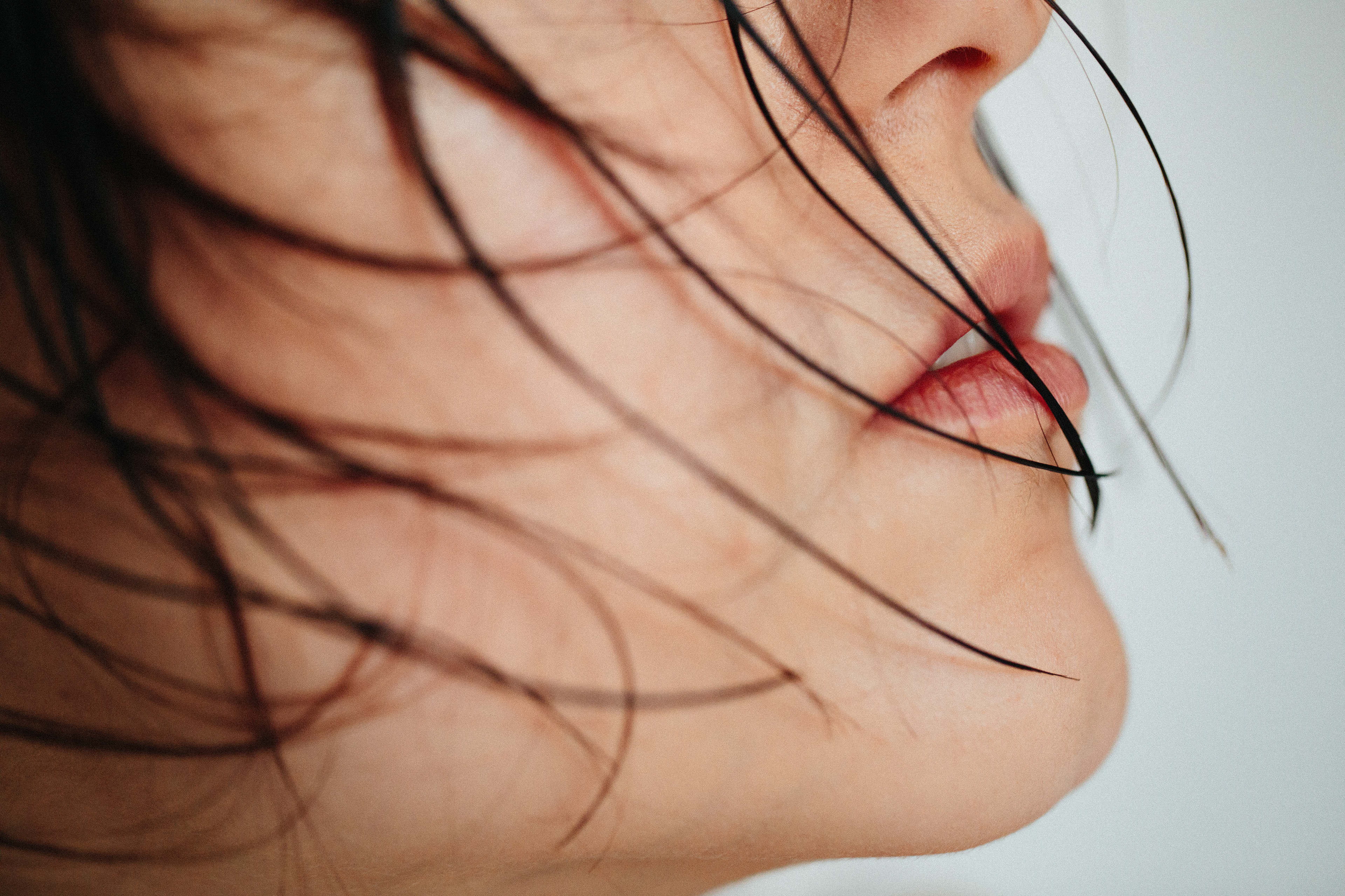 acqueline steht vor einem schlichten weißen Hintergrund und strahlt Selbstbewusstsein aus.