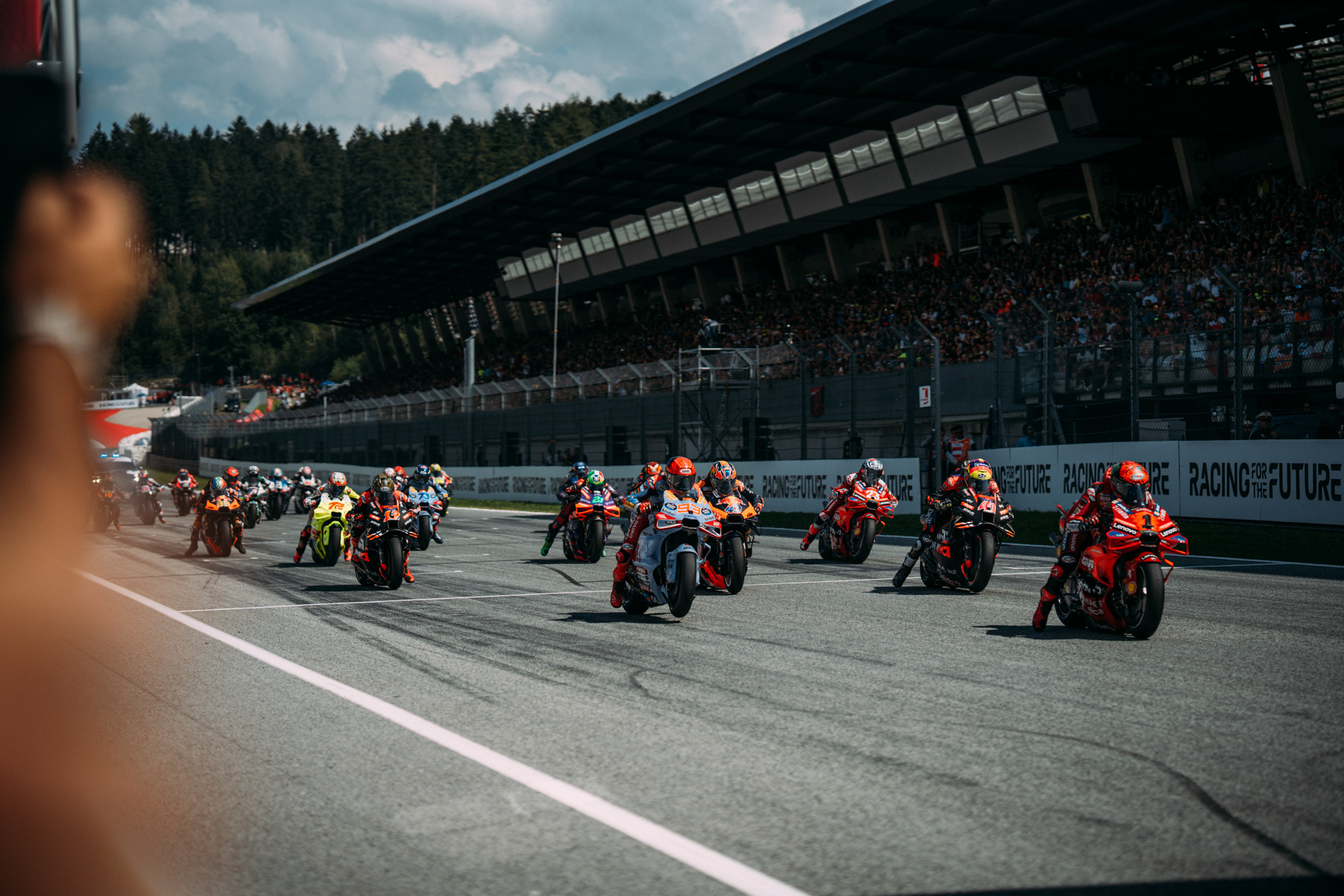 MotoGP-Bike in Bewegung, AlphaTauri-Fahrer in Action auf urbaner Strecke.
