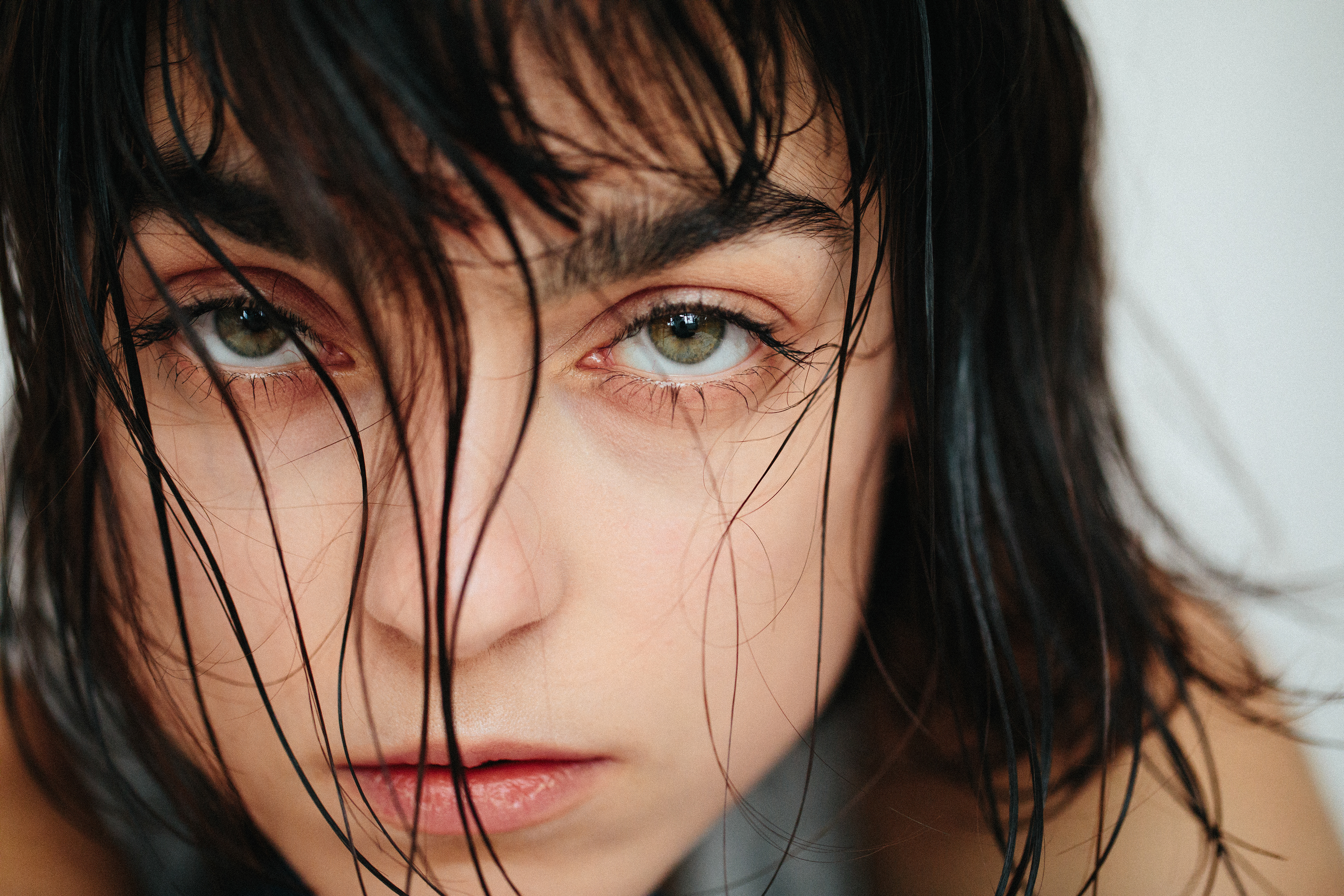 Model Jacqueline posiert vor einem weißen Hintergrund mit natürlicher Eleganz.