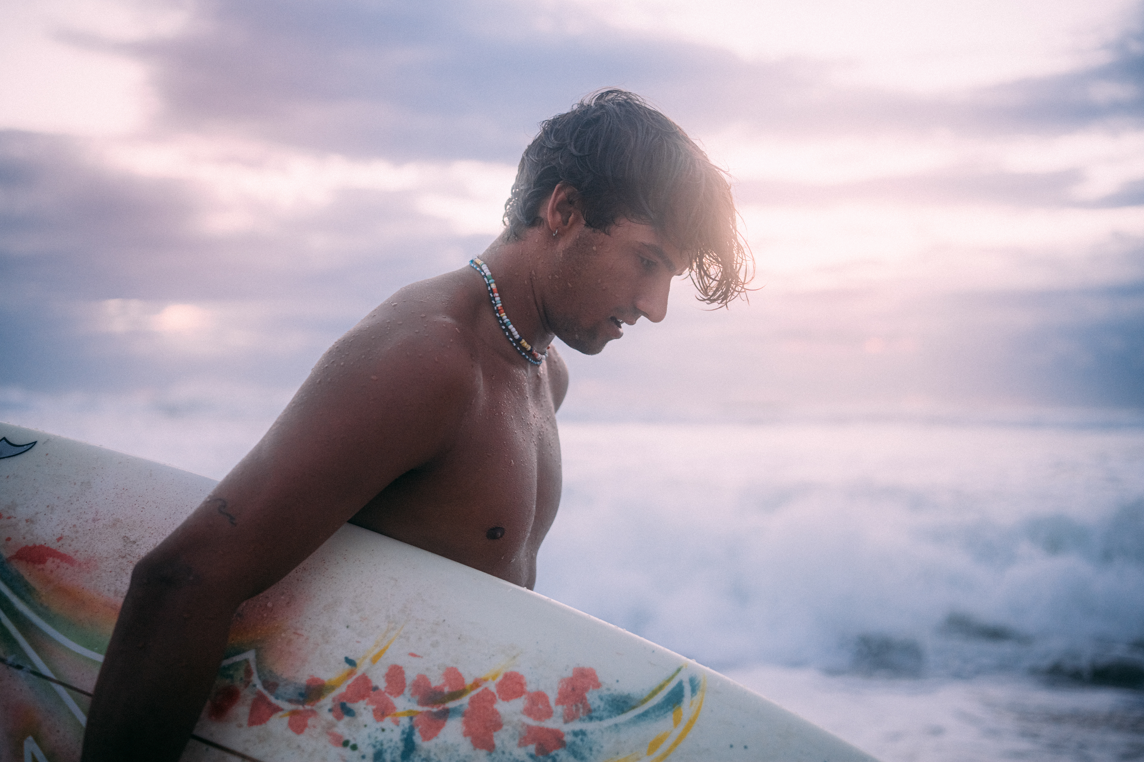 Dynamische Aufnahme eines Surfers, der in der Dämmerung eine perfekte Welle reitet