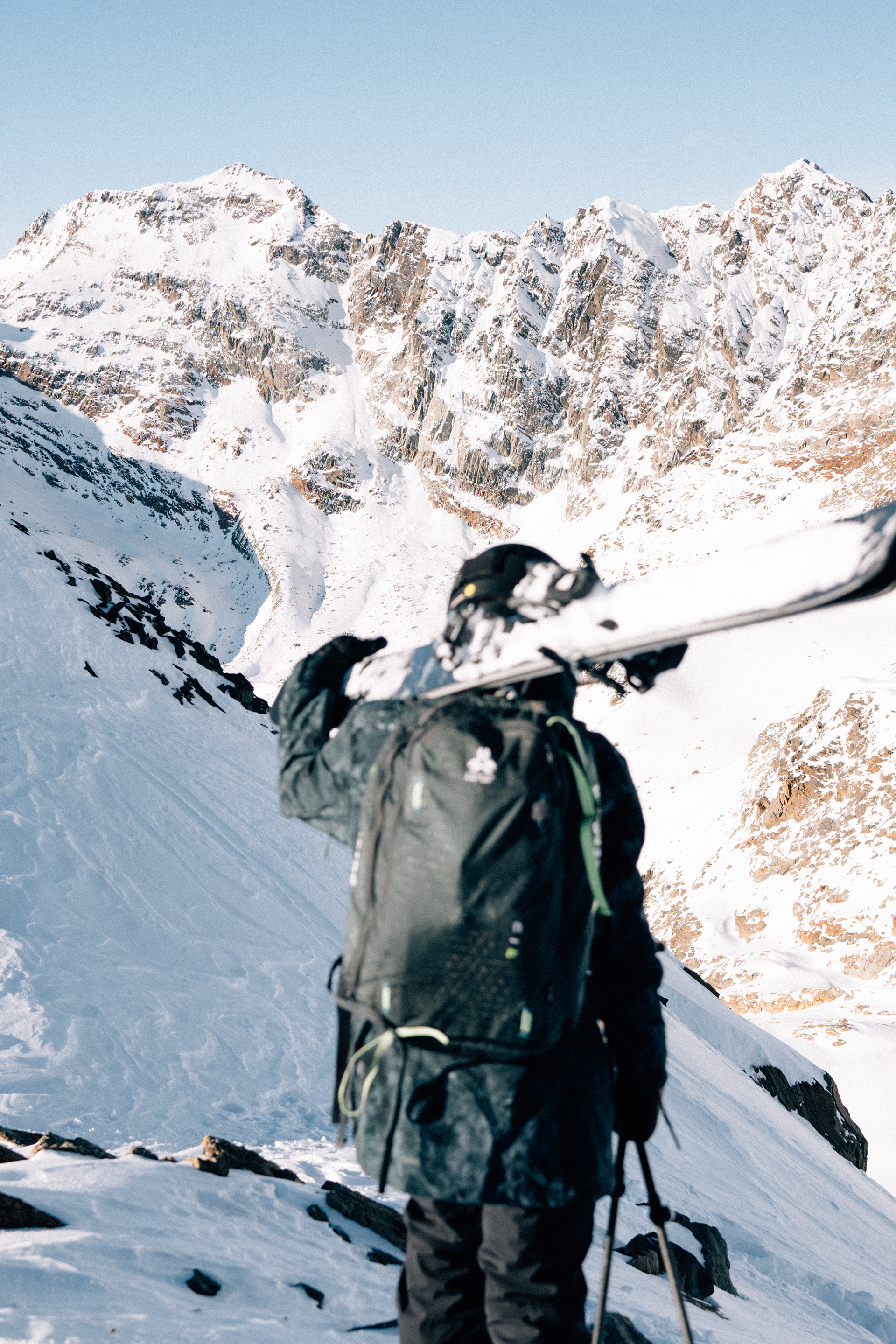 Lea Bouard in einer majestätischen Berglandschaft – verschneite Gipfel ragen im Hintergrund auf, während die Freestyle-Skifahrerin in die Weite blickt.