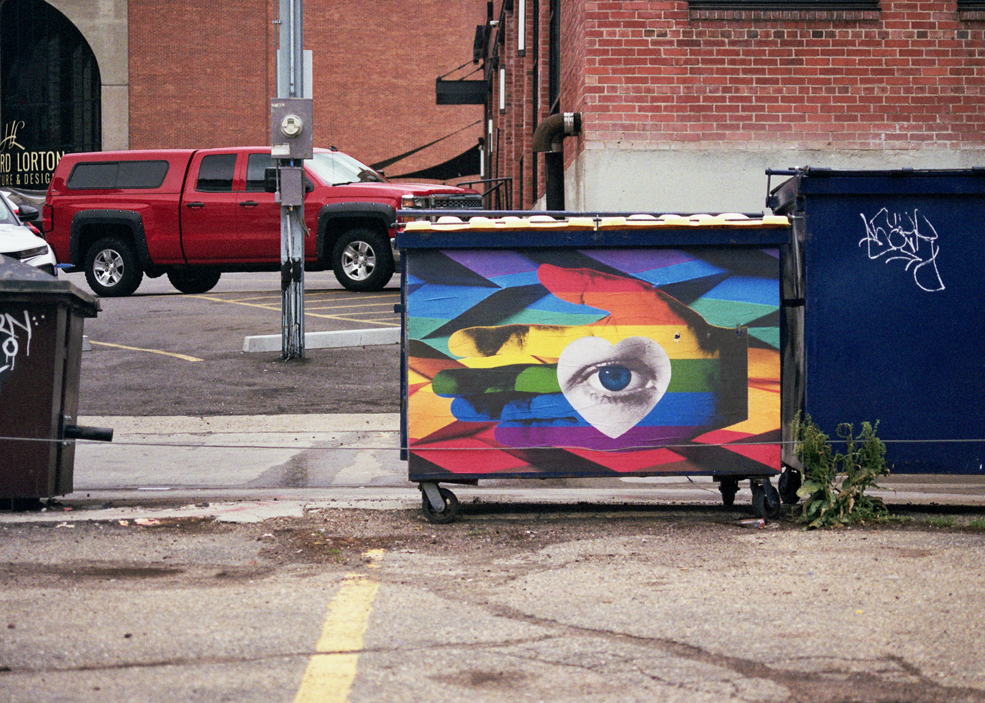 A rainbow-painted dumpster.