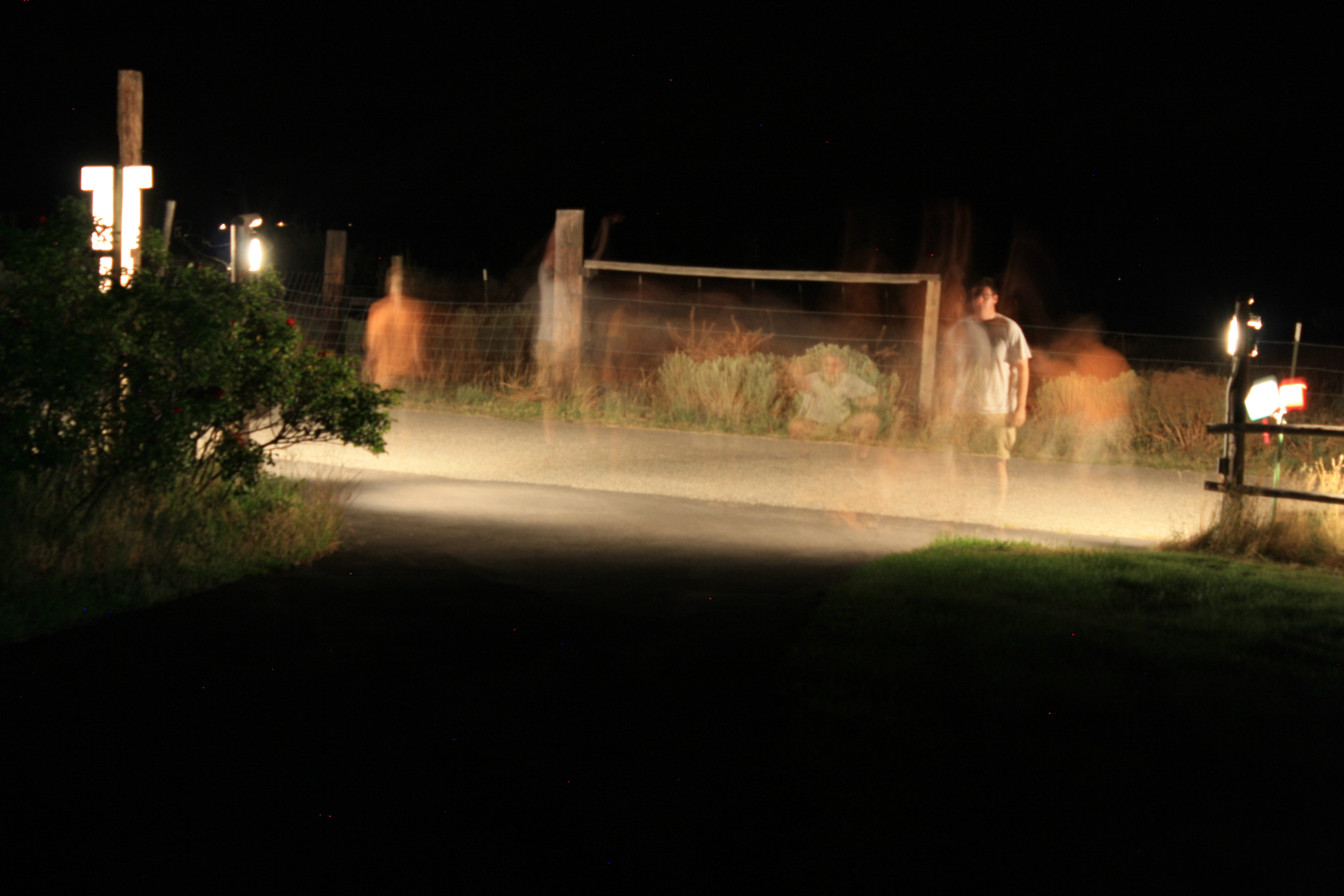 Long exposure of two people dancing and jumping in the dead of night.