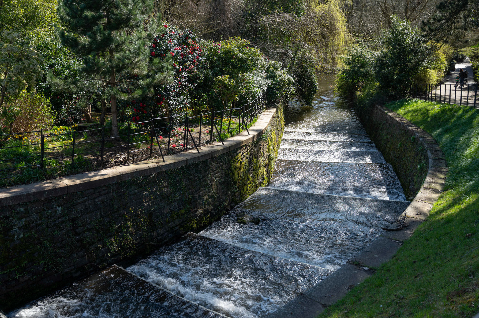 Dappled lights on the cascade at Roath Park, Cardiff, South Wales, UK on a sunny spring morning.
