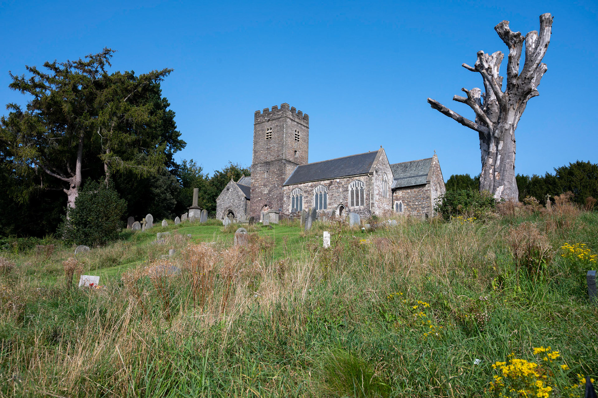 St Mellons Parish Church, Cardiff, against a clear blue sky.
