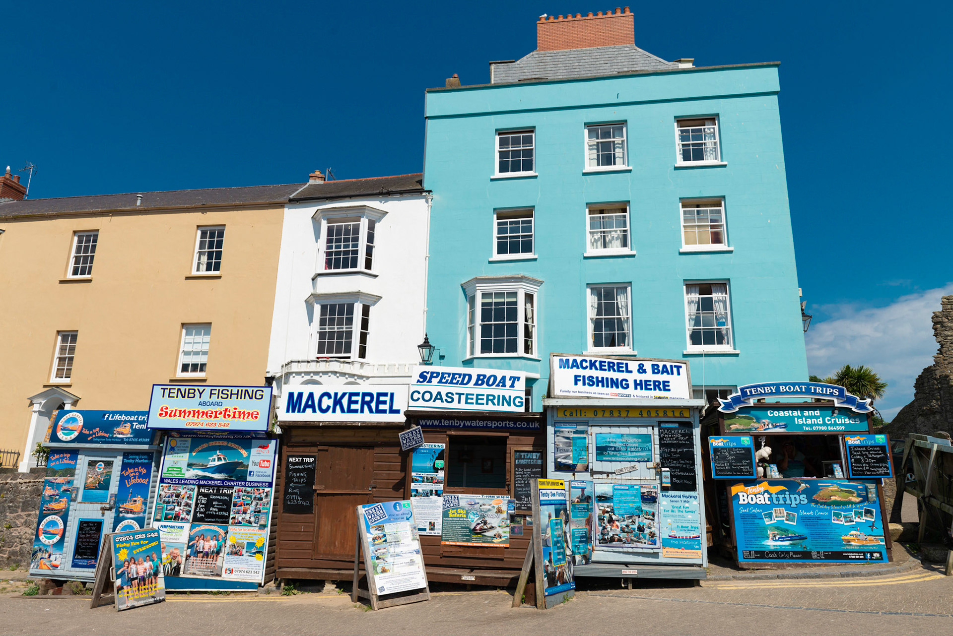 Huts selling boat trips in the pretty seaside town of Tenby, Pembrokeshire, Wales, UK.