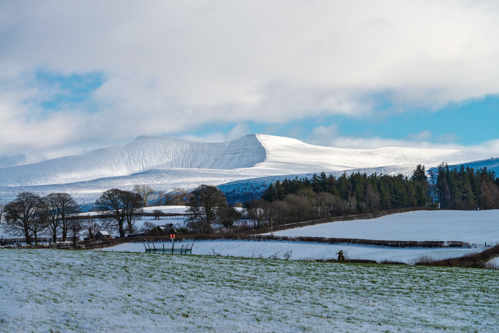 Late afternoon sun catches a snow covered Penyfan in The Brecon Beacons, South Wales.