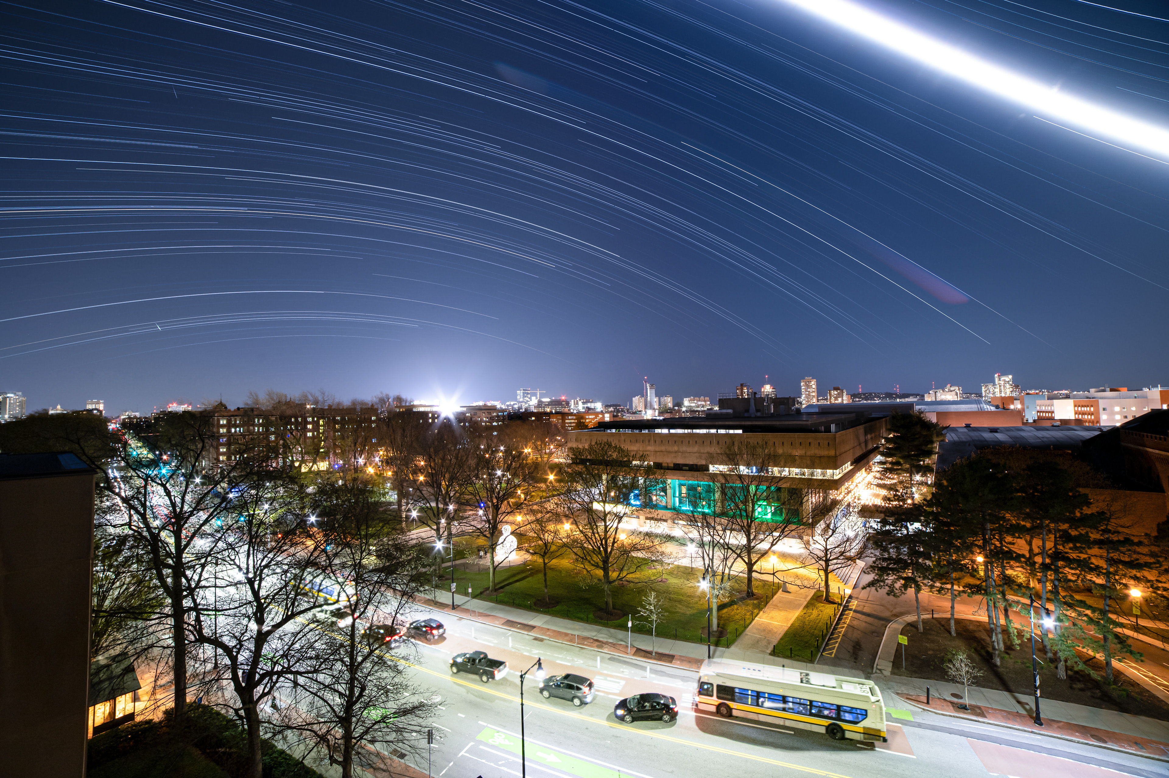 Star trails and the moon pass over Mass Ave and the Alchemist sculpture. Cambridge, MA.