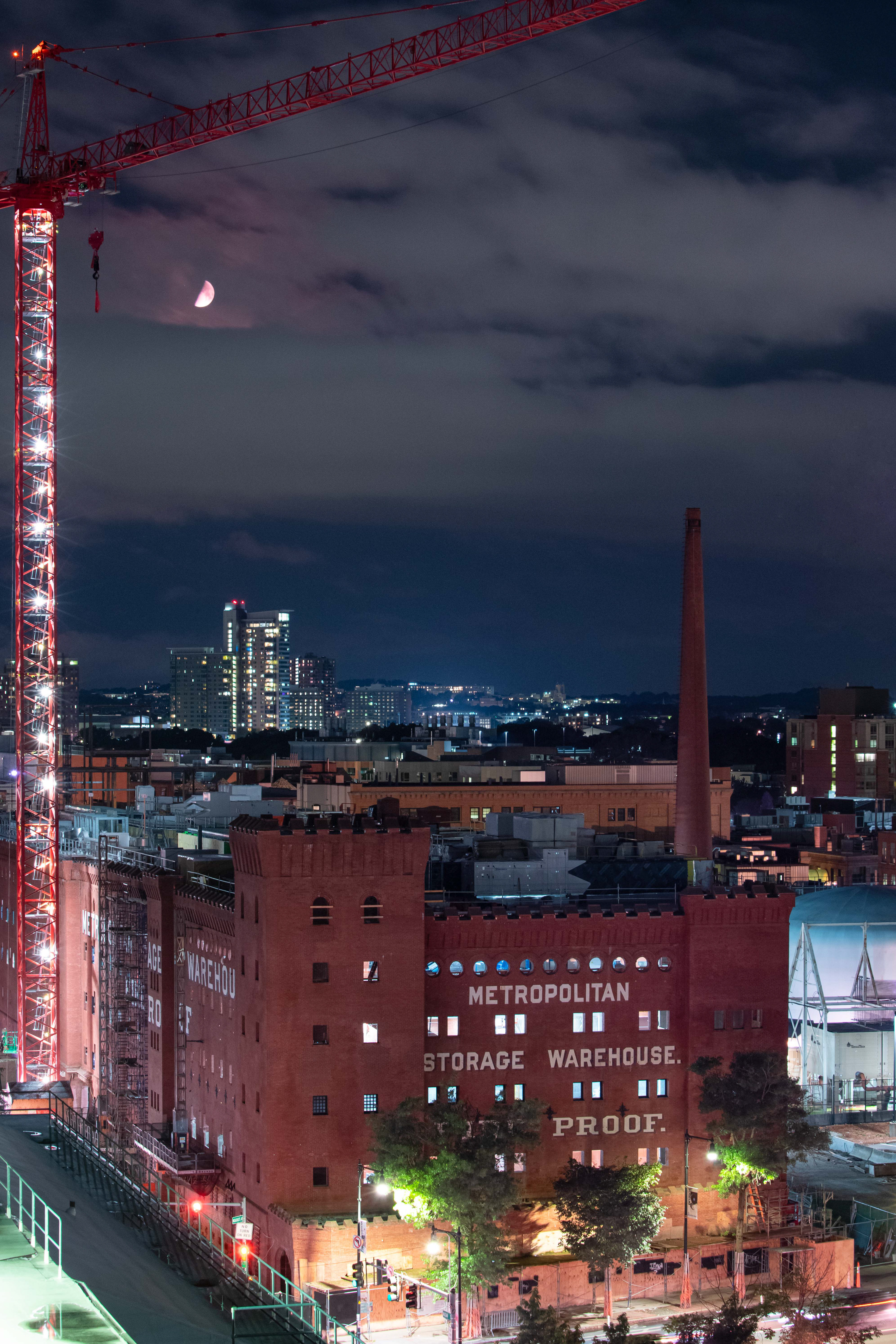 First quarter moon sets above a storage warehouse. Cambridge, MA.