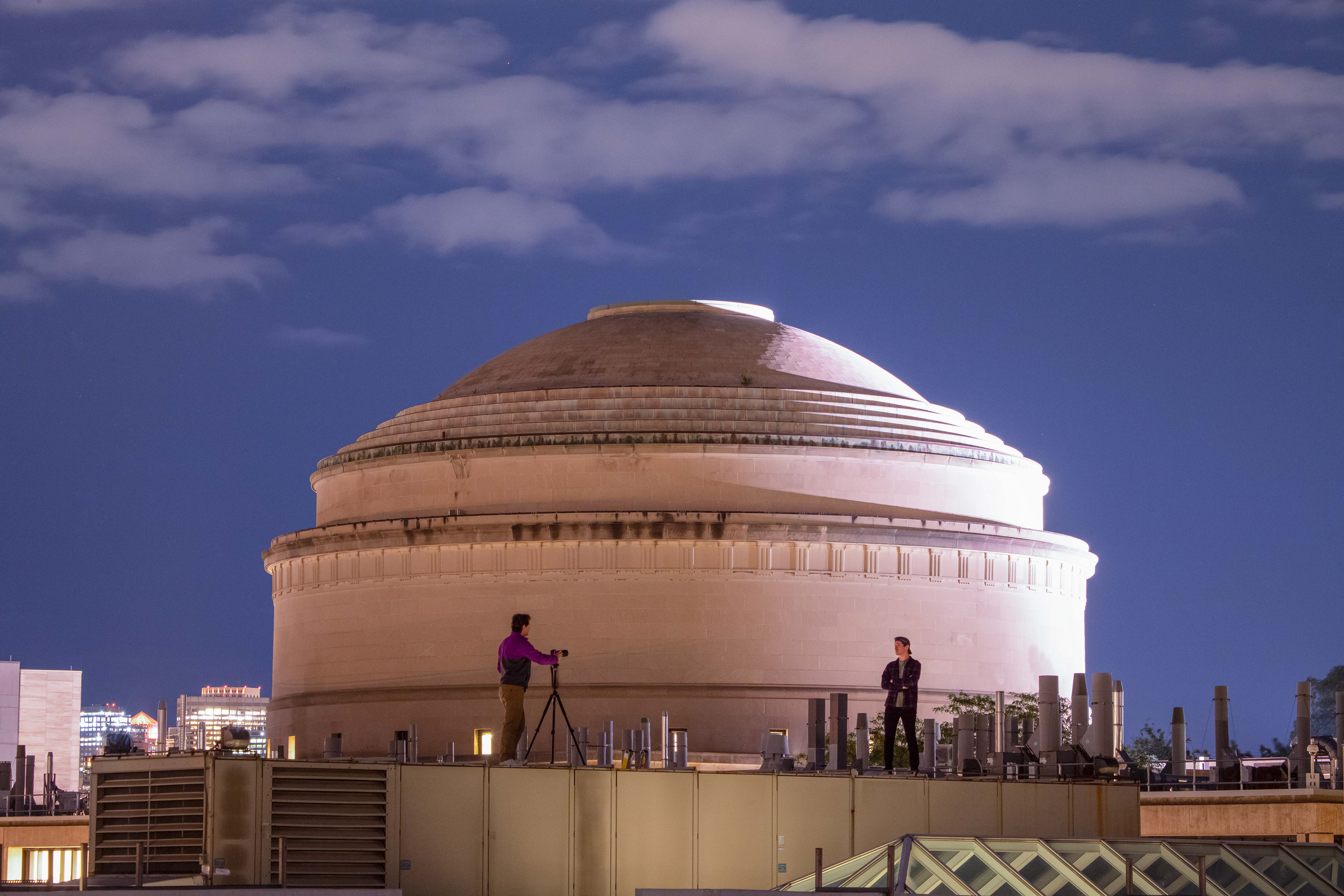 Evan Kramer (left) stands on the roof of MIT building 33 with a camera and tripod while capturing an Astro Portrait of Noah Salk. Cambridge, MA.