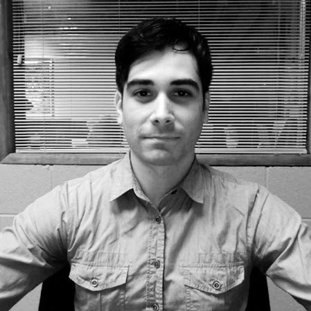 David Becker sitting at desk smiling at camera.