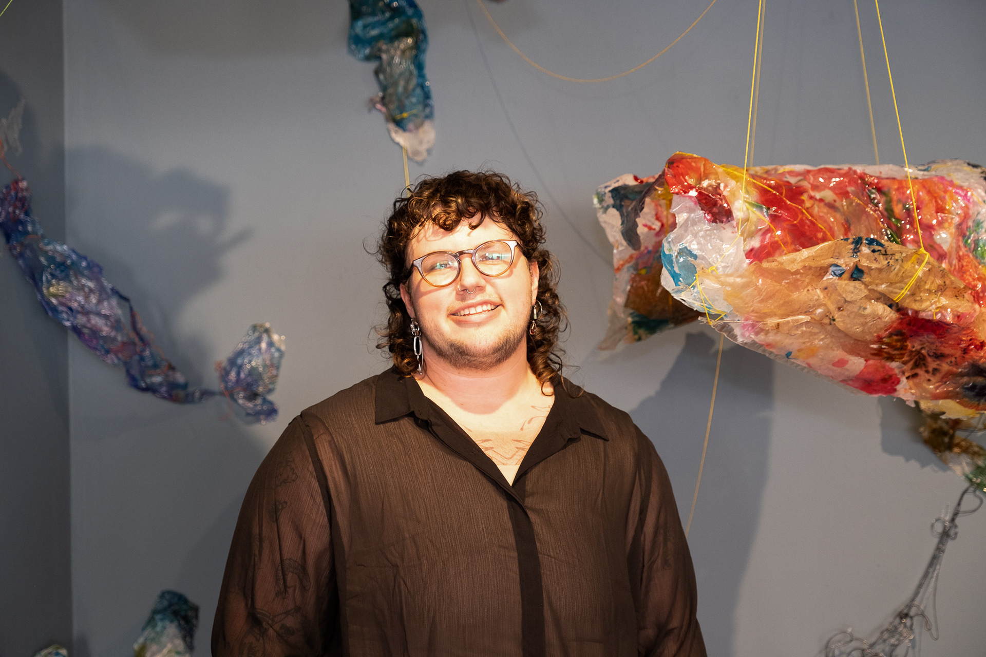 Image of the artist, Halley Bohm, with their work.