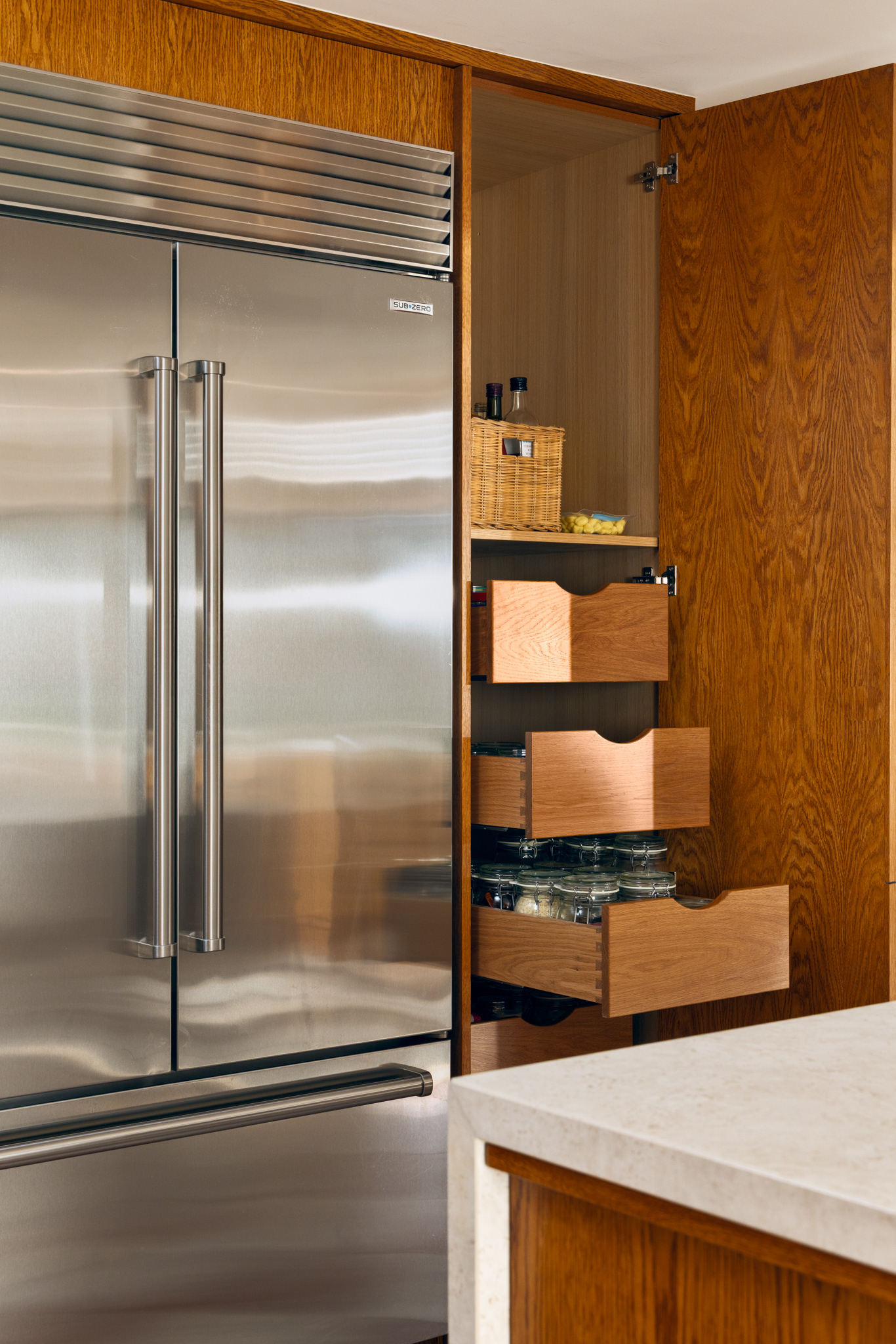 Premium Sub-Zero refrigeration integrated within bespoke oak cabinetry to create a refined and functional kitchen.