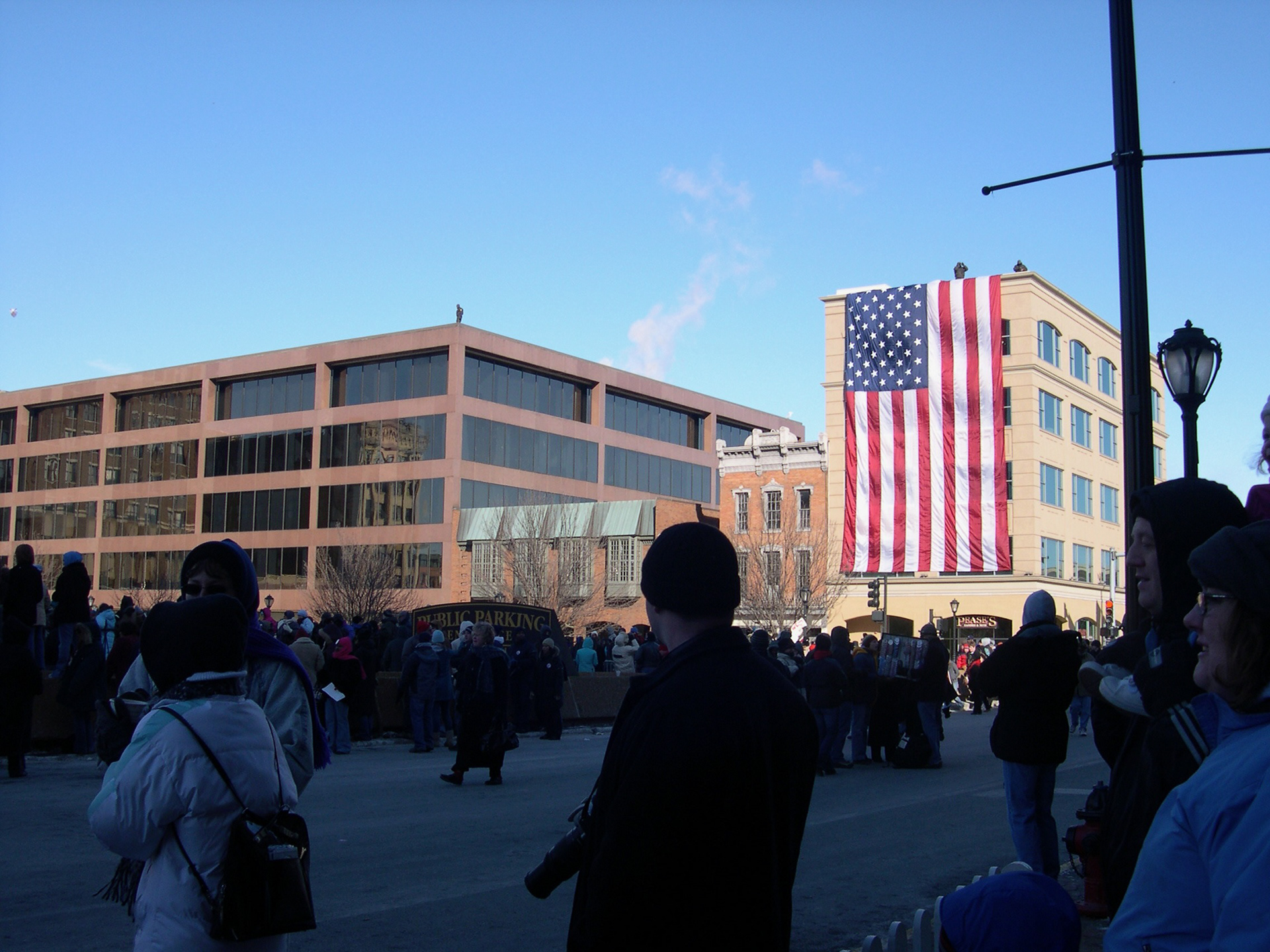 A United States flag is draped over the side of a building where security personnel monitored the crowd.