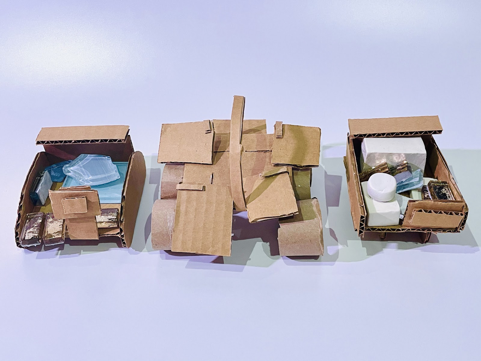 The stones and white clay represent boxes to show much space the vehicle would have. The middle model explored an expanding plate to carry an increased amount of boxes when needed.