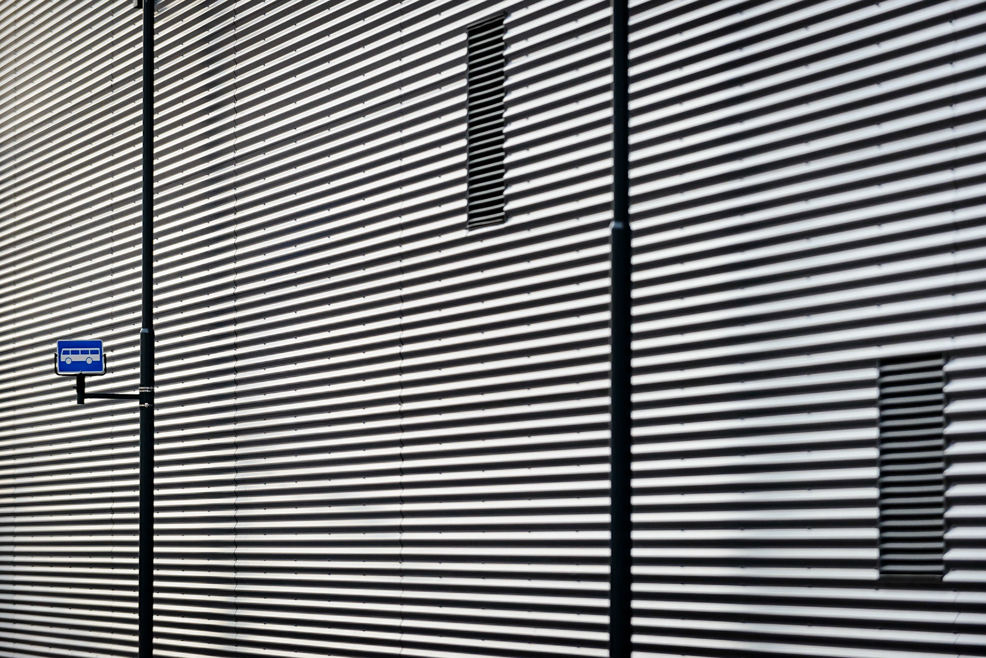 Bus stop ifront of a cool wall.