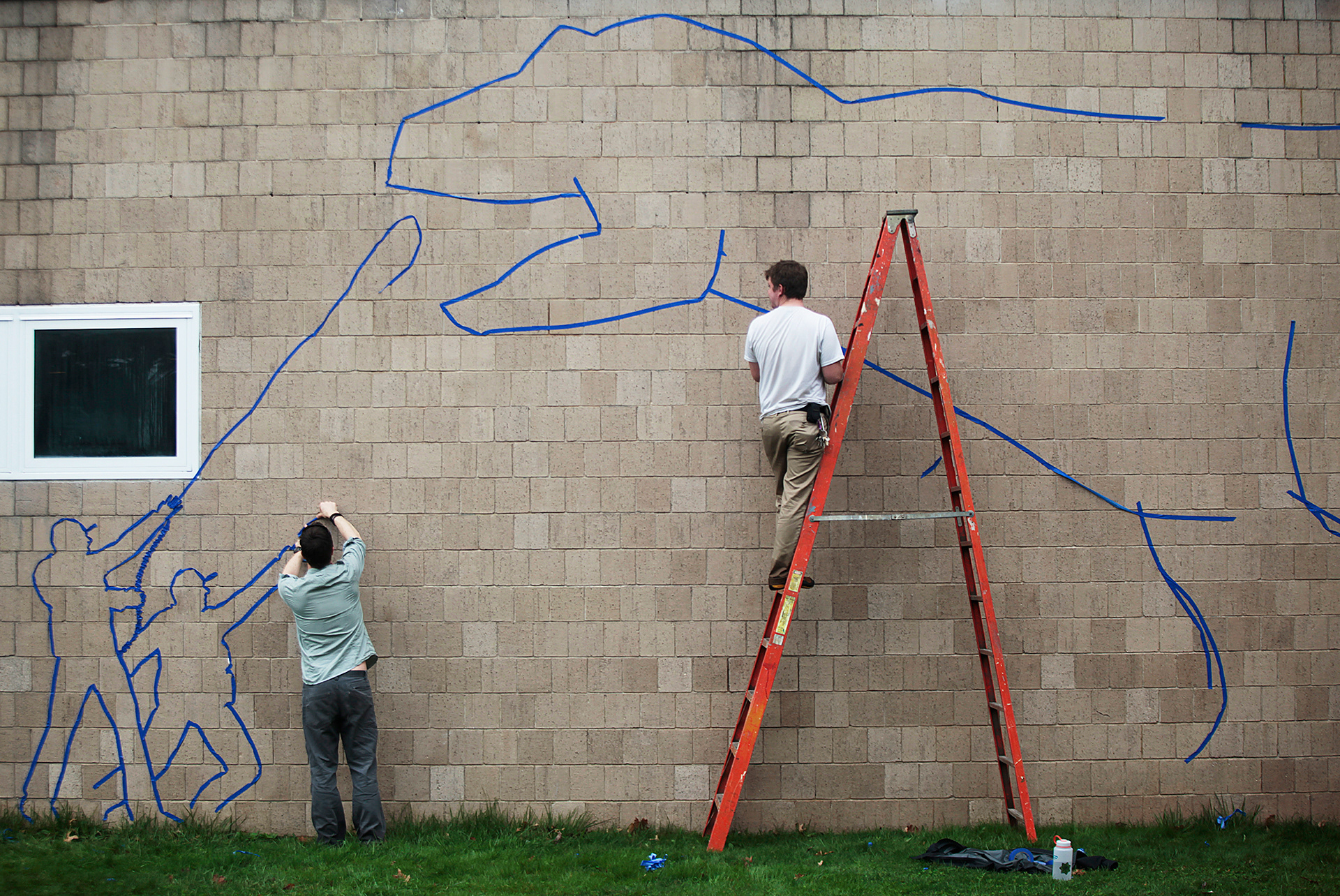 Students create a Tyrannosaurus Rex out of tape.