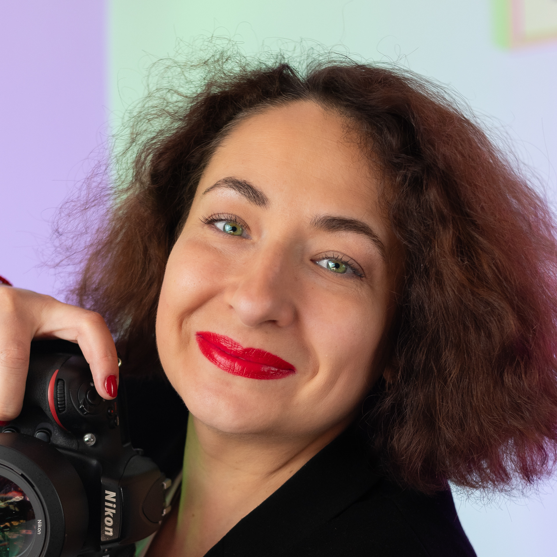Professional female photographer specializing in employer branding, holding a Nikon camera. She is depicted in a business setting, illustrating her expertise in creating powerful employer branding imagery.