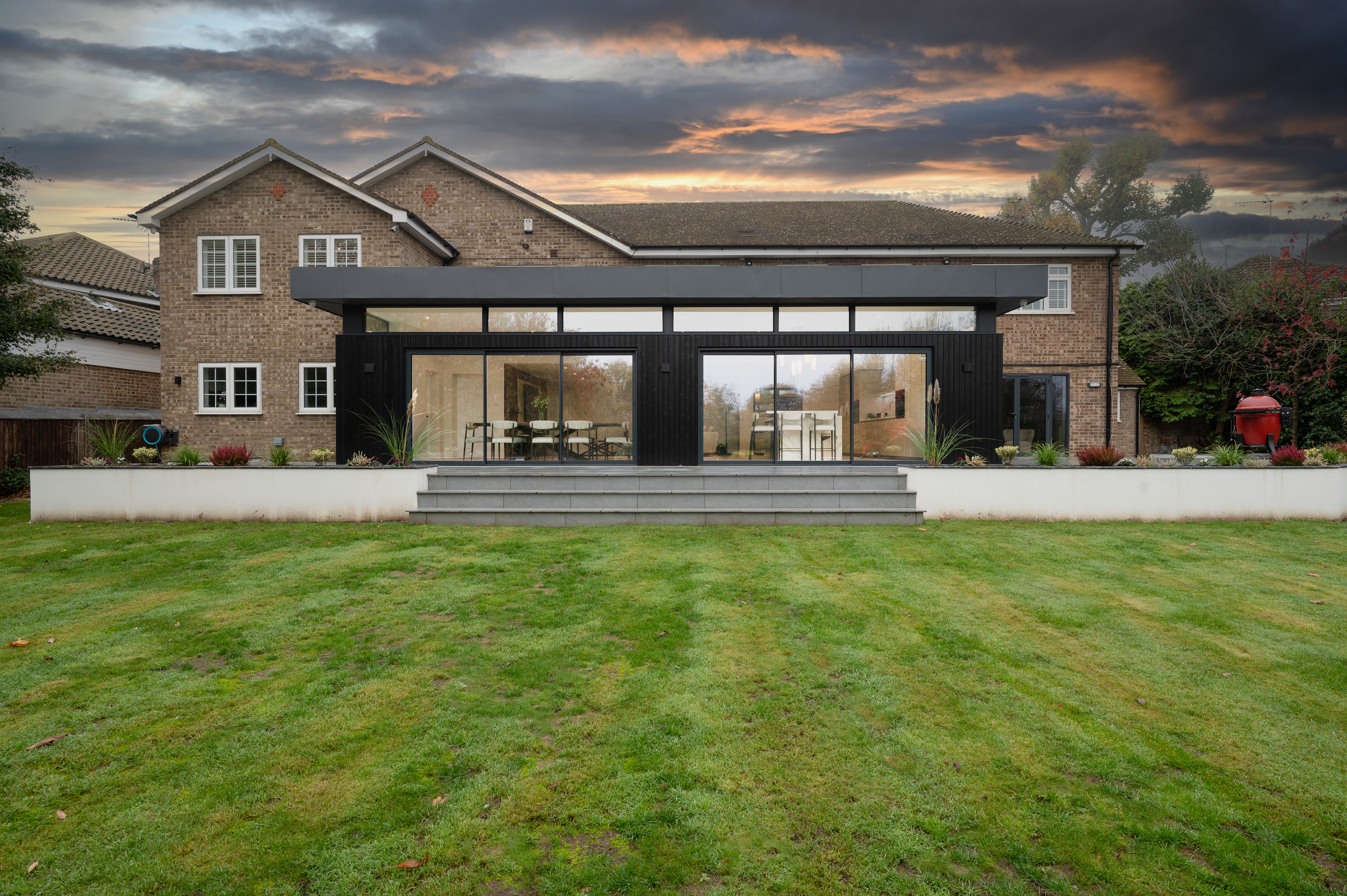 A photograph of the rear elevation of a house with a modern glass box extension.
