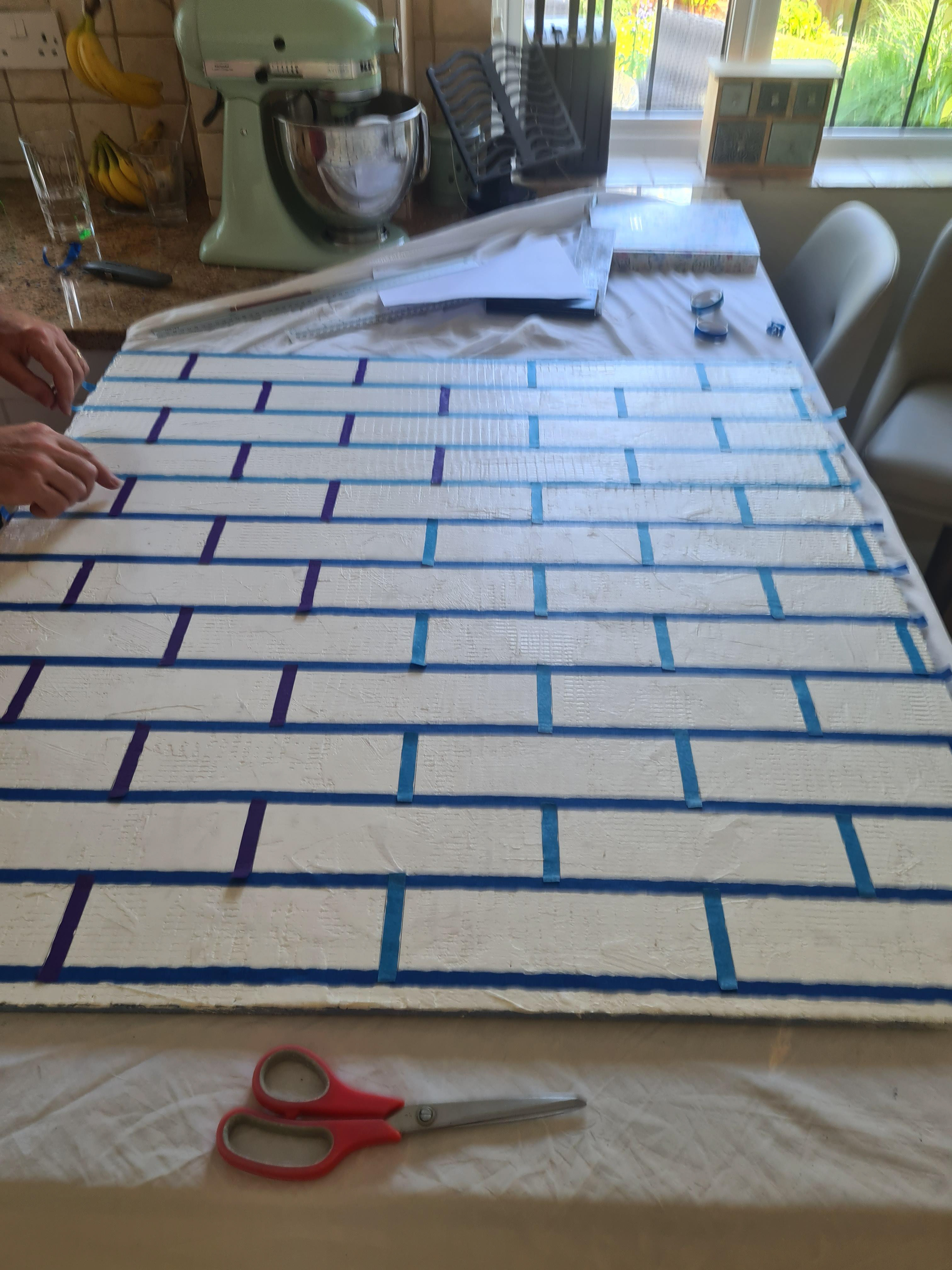 Using masking tape to mark out the bricks