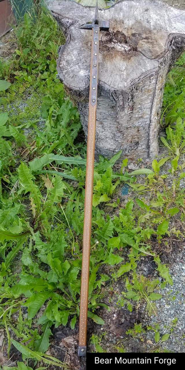 warhammer with teak handle, studded with brass studs. there are several hundred studs in this piece. The hammer head was patinated to look like case hardening.