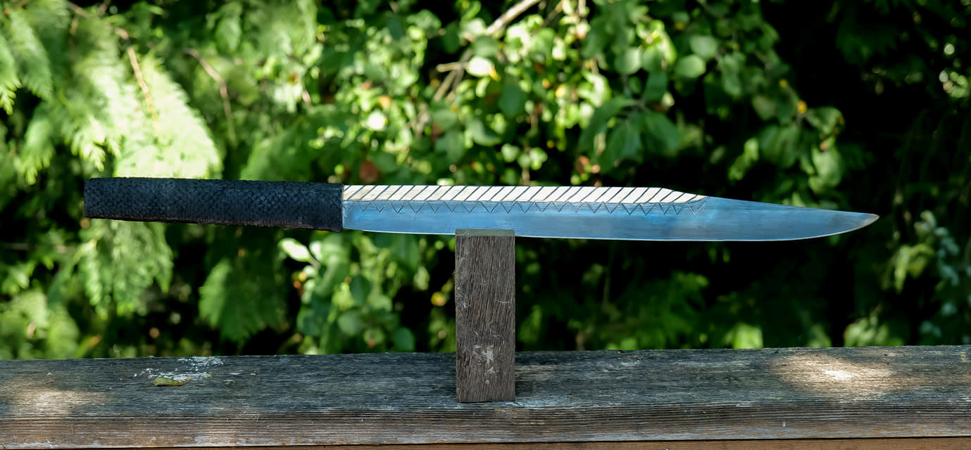 large seax, 80crb2 blade with engraving and 24 karat gold plating, grip is poplar wood with oak burl end caps, and wrapped in salmon leather