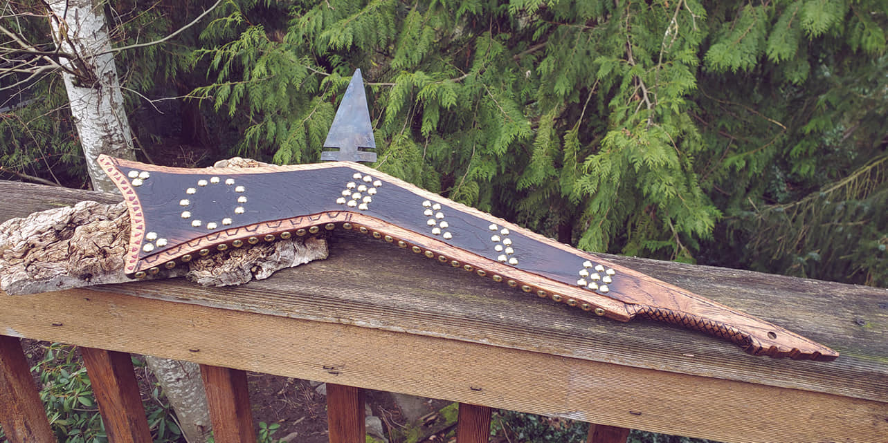 Sioux-Santee Gunstock Club. Body is hickory with wood burning and carving. 200 studs in a historical pattern, blade is 1075