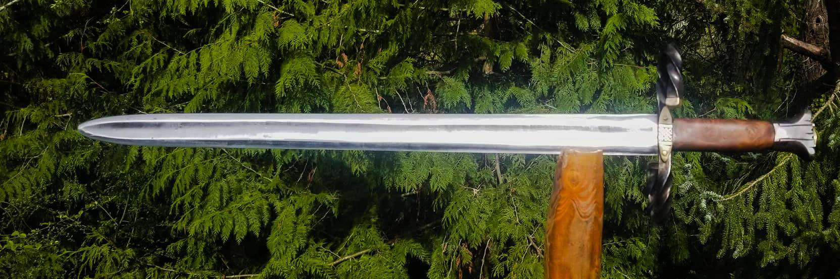 46 inch long sword with 35.25" blade. Pommel is hollow ground and filed. Fittings are mild steel heat blued than chemical blue topper that I brushed back to a dull grey with the heat blue shimmering through. Handle is Wenge wood, with inlaid twisted copper wire, bordered with tooled and dyed leather sealed with boiled linseed oil. Peen block is brass. Blade is 6150. Weight is 3lbs 12 ounces with a POB of 3.5 inches.