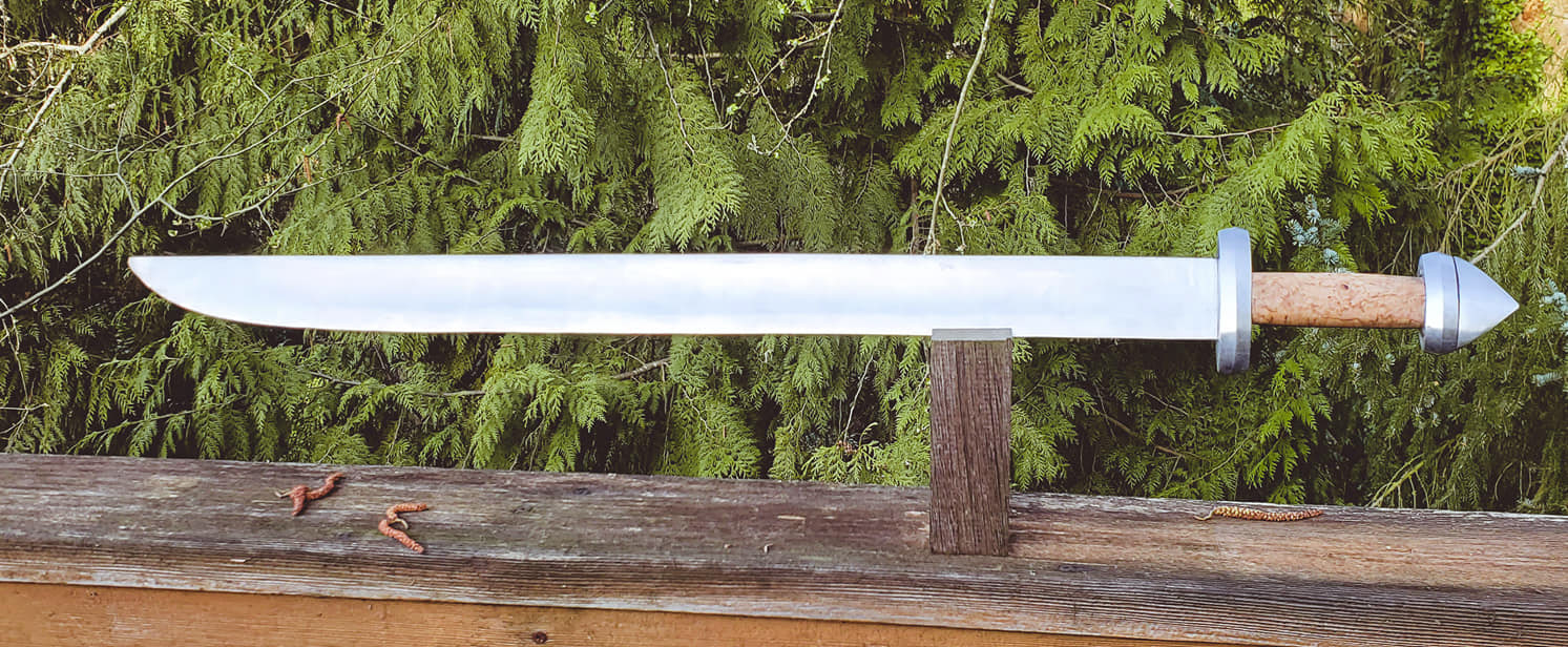 Single edged viking sword with a long shallow fuller. 5160 blade with mild steel hilt, grip is masur oak burl
