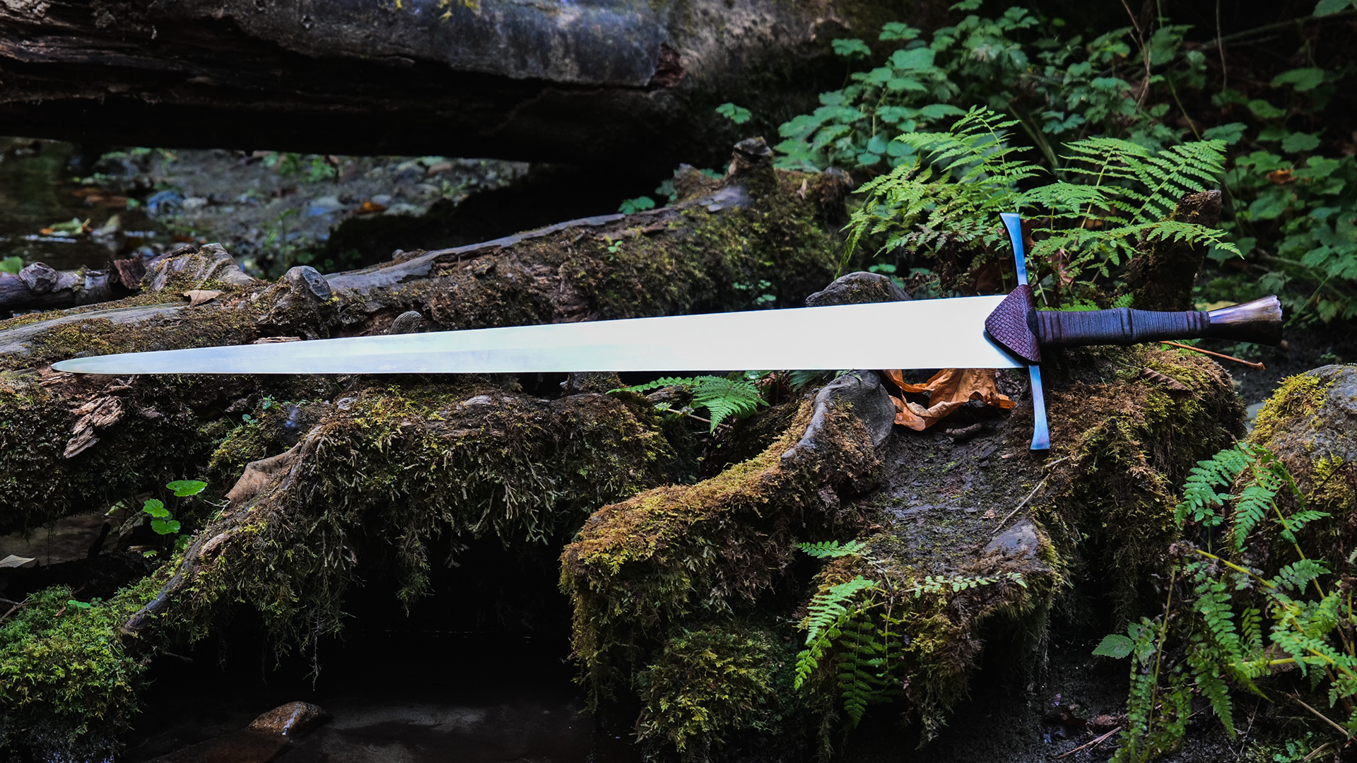 Type XVIIIc, 35.5" blade (3"wide) in 5160, oal is 45". Guard and pommel are 1018 which has been fire blued, pommel as decorative filework and a brass peen block.
