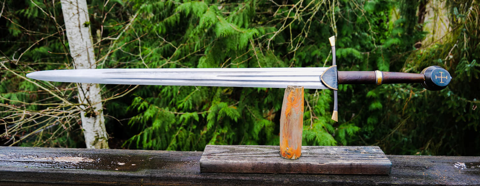 Type XIIa. 5160 blade, forged rain guard has filework, as does the hollow pommel. Fire blued hilt furniture, 24 karat gold plating all over including the big band on the side of the pommel. 46" oal, 34.25" blade with a pob of 3.5".