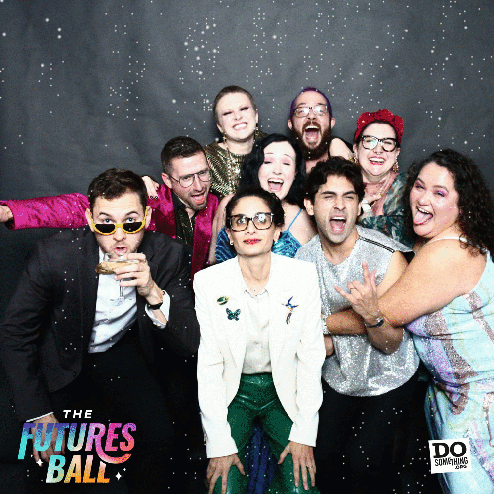 Group photo of the DoSomething.org team posing playfully in a sparkle-themed photo booth at The Futures Ball. Everyone wears bold, expressive formalwear with big smiles and exaggerated gestures. The animated photo booth frame includes glittering effects and event branding, aligning with the gala’s maximalist, celebratory tone.
