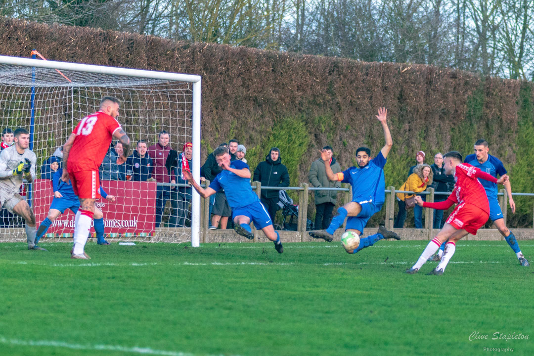 Chaos in the Heather St Johns FC defence in the first half as Corey Bucalossi of Gresley Rovers FC fires a shot which is blocked by the Heather St Johns FC defence, In the United Counties Premier Division North League match between Heather St Johns and Gresley Rovers played on 3rd Jan 2022.