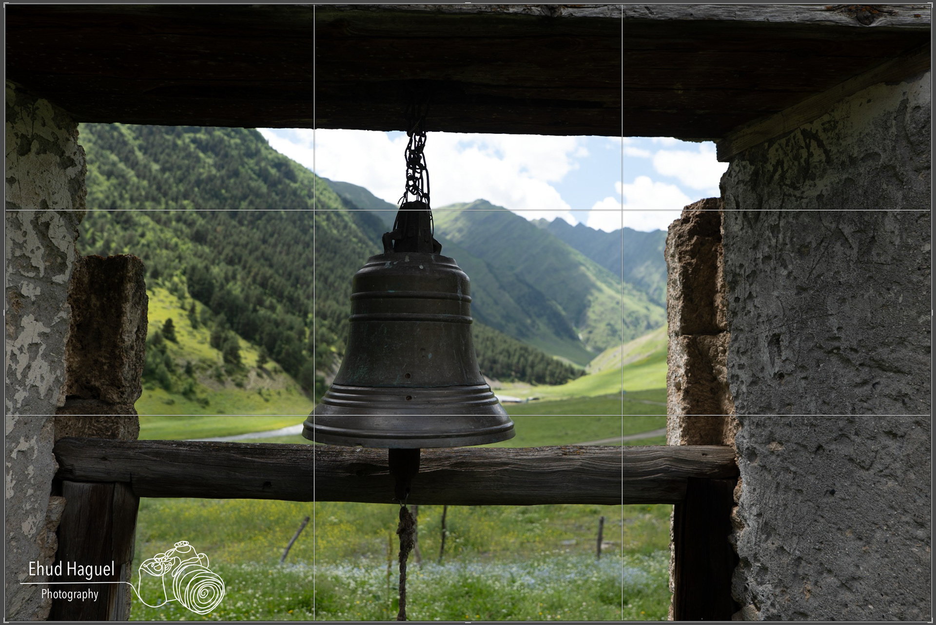 Church bell framing mountain valley, composition photography Georgia