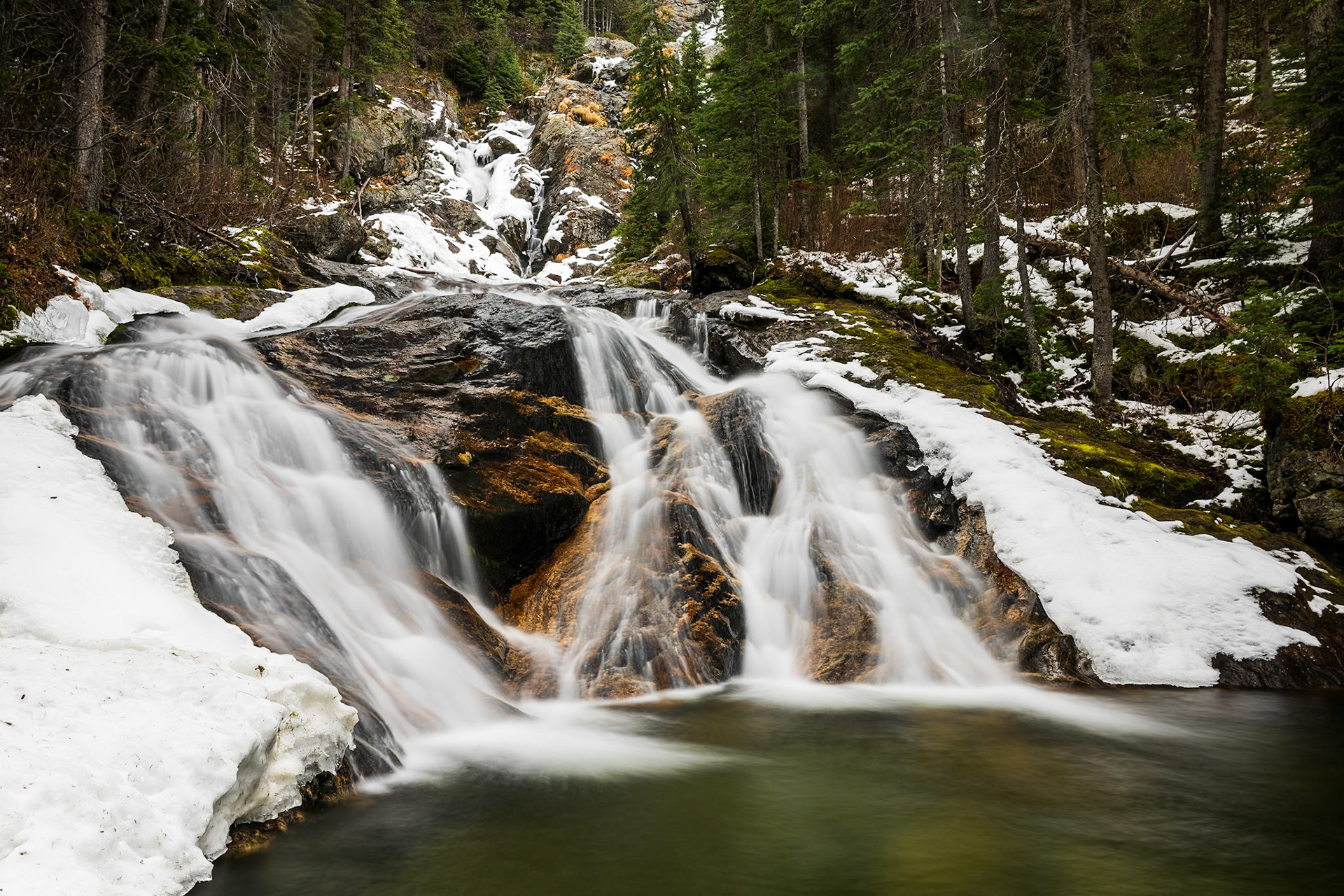 Early season snow frames the many levels of scenic Silvertip Falls. At 168 m, it is actually one of the tallest waterfalls in Wells Gray Provincial Park.