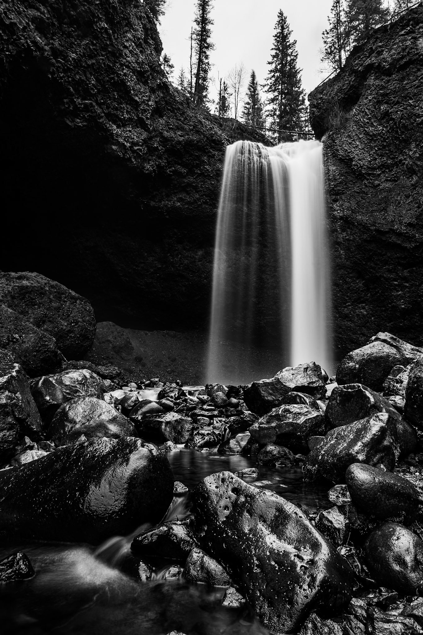 A black-and-white study of Moul Falls captures the interplay of light and shadow on wet rocks and shimmering pools.