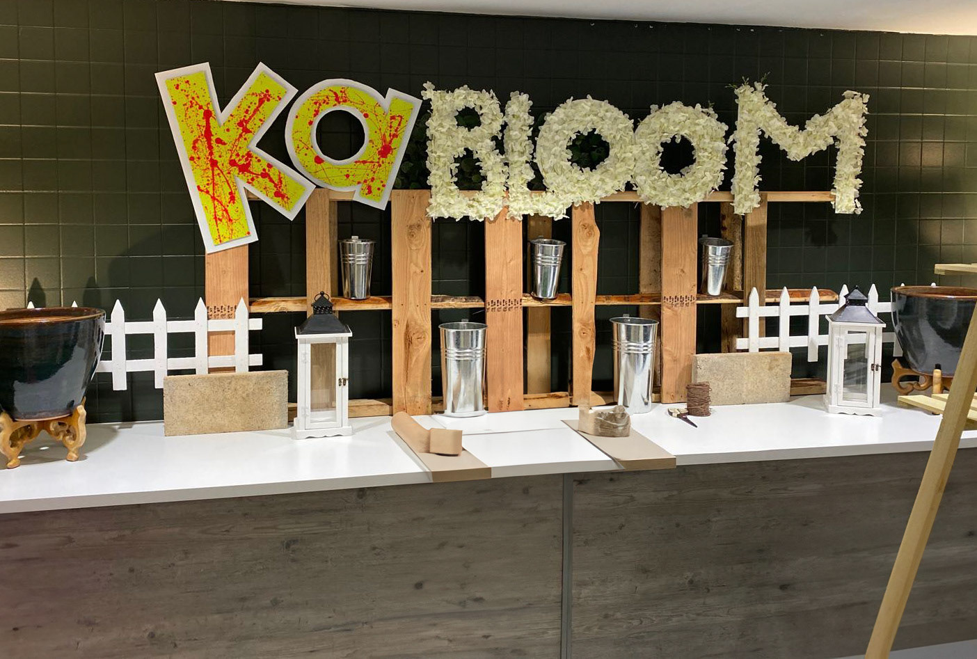 gardening brought into the shop with a palette, flower bed fencing, candle hurricanes, and cobblestones