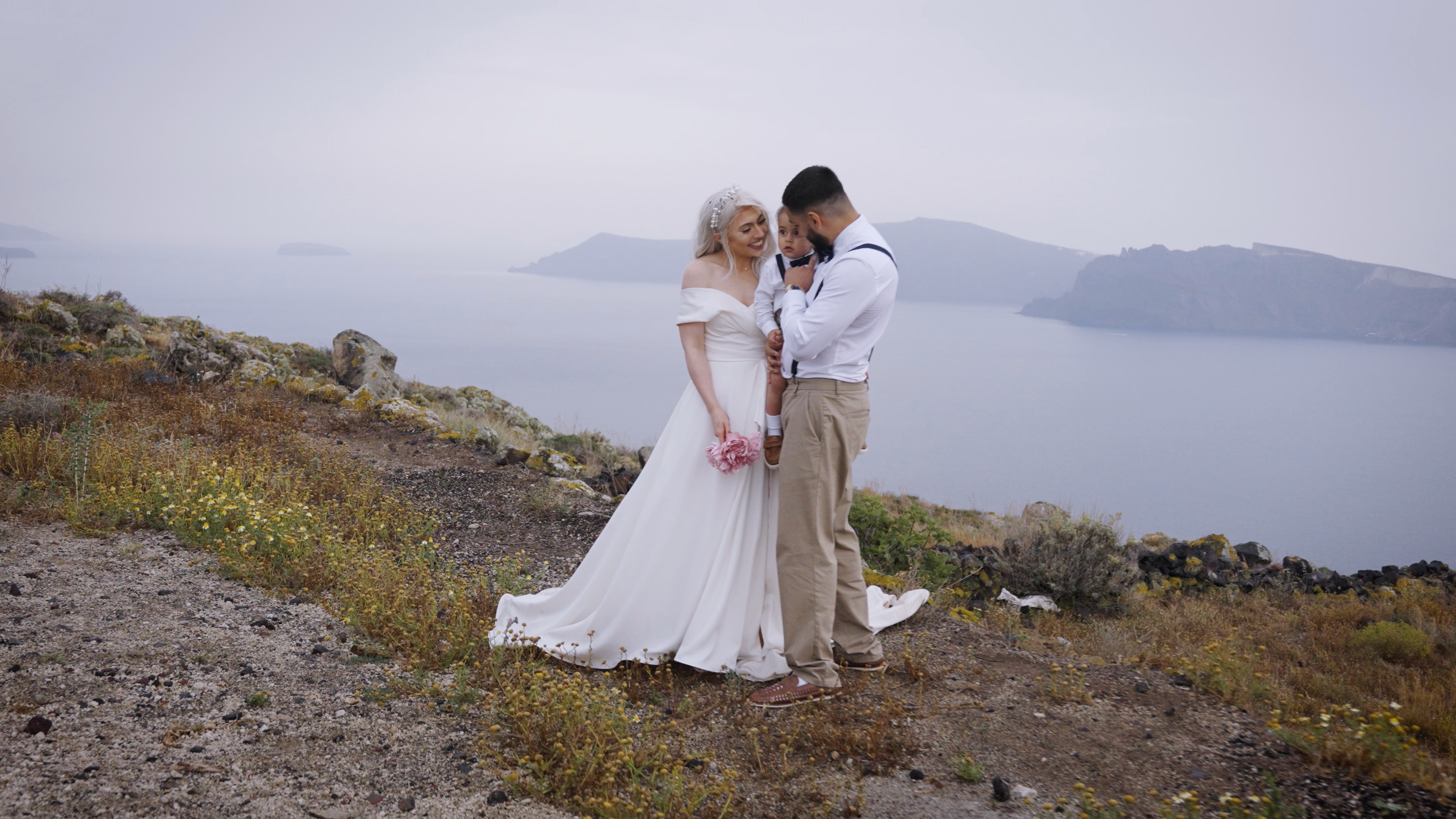 Cinematic shot of a couple, cliffside, in Santorini Greece