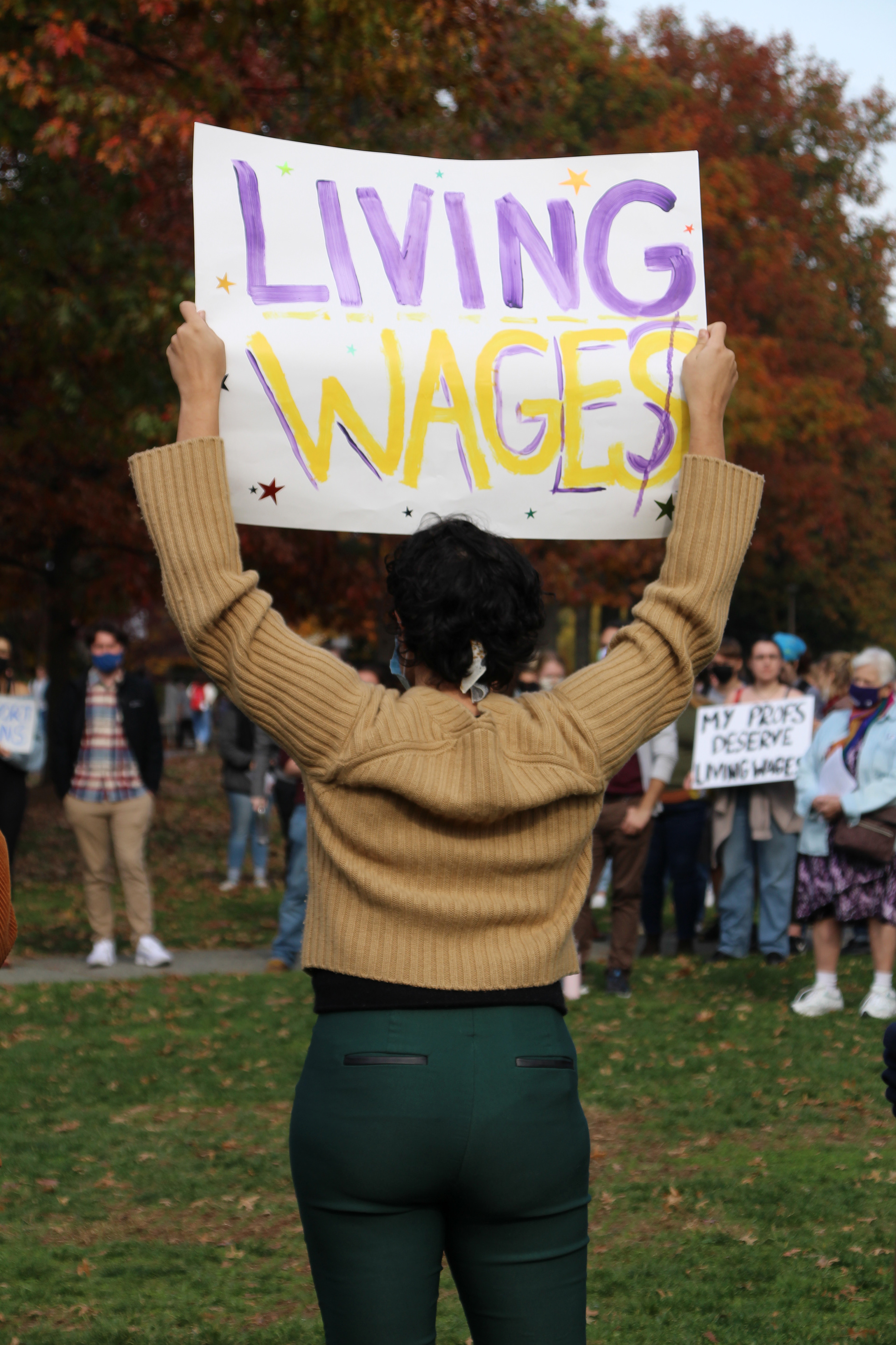 A woman holds a sign to support living wages in Washington, D.C. on November 11, 2021. (Lia Chien/The Eagle)