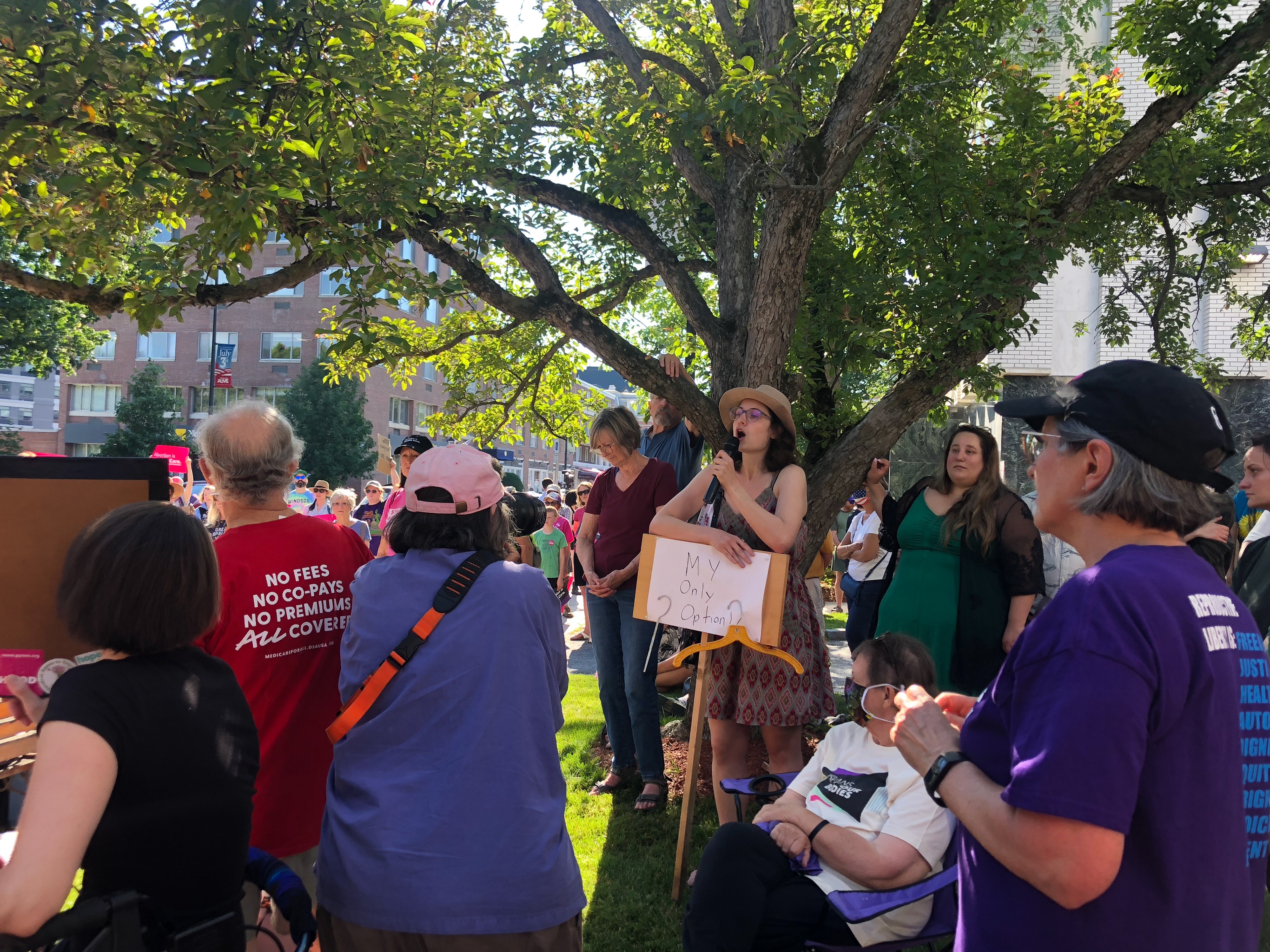 A woman holds the microphone and shares her story at the Montpelier Roe v. Wade protest on June 24, 2022. (Lia Chien/VTDigger)