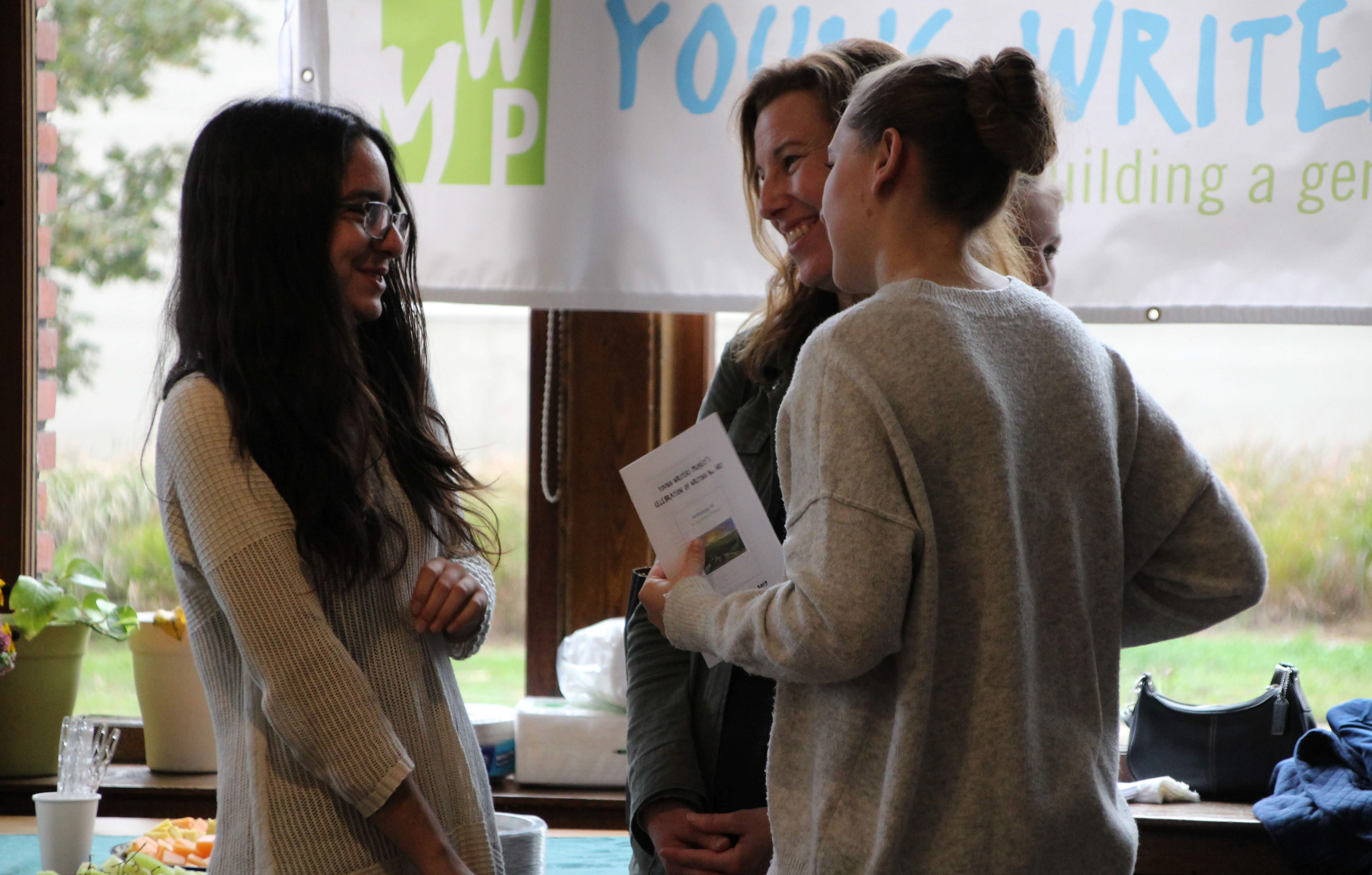 Three participants have a conversation at the YWP book launch on October 6, 2019 in Burlington, Vt. (Lia Chien/YWP)