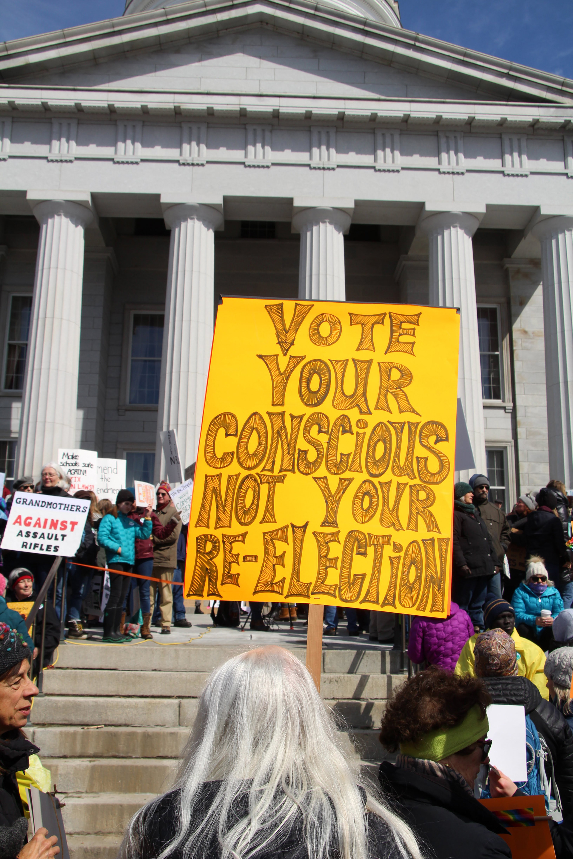 A sign is held in front of the Vermont State Capitol Building on March 24, 2018 in Montpelier, Vt. (Lia Chien)
