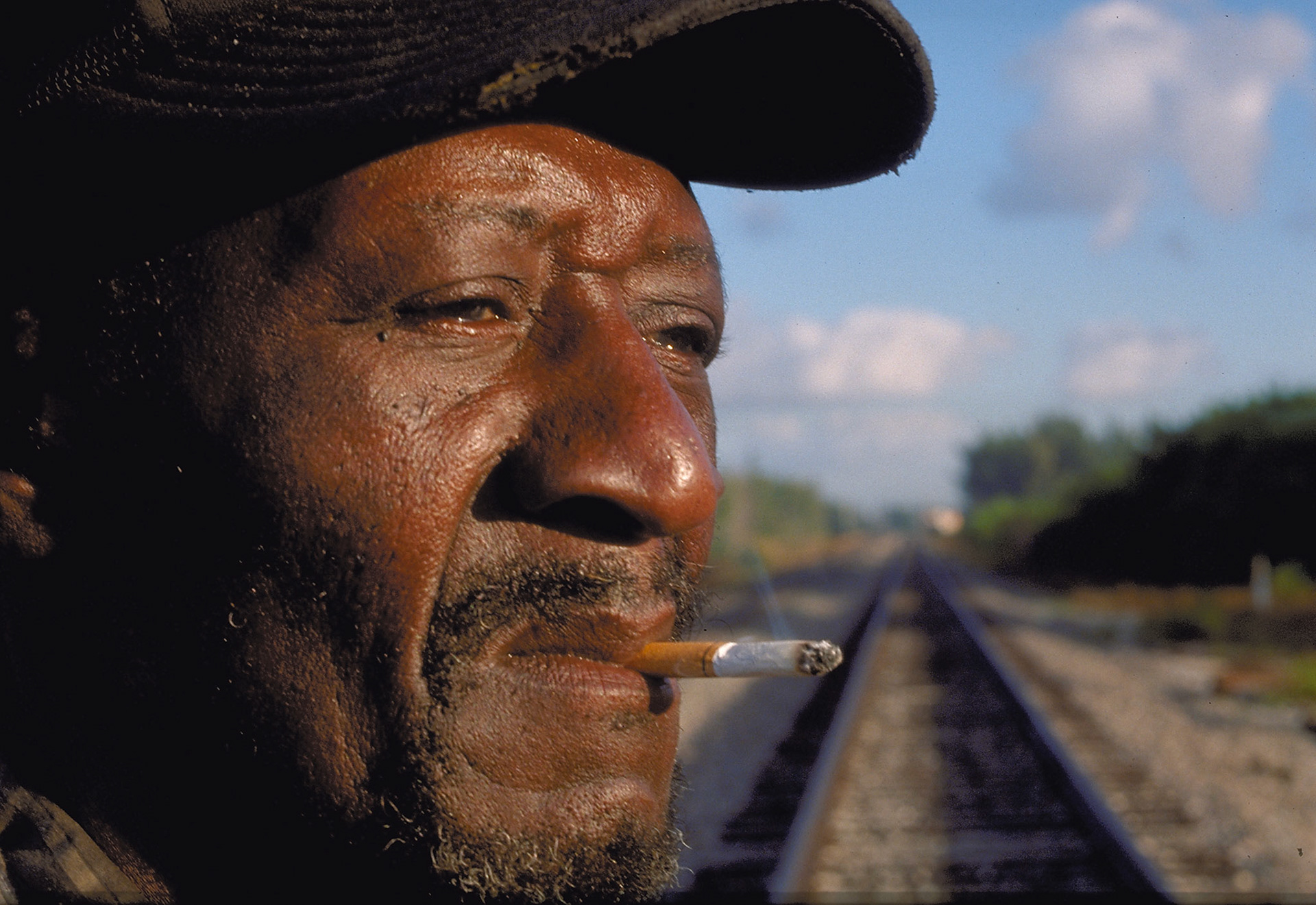 Hugh Smith, 60-years-old, from Macon, Georgia posed for this photograph while walking down the tracks headed for Miami, Florida.  He had been working in an orange grove and was in route via freight trains to visit relatives.  I bought him some food and offered him a ride, which he declined.  "I perfer to walk," he said.  Personal workphoto by Gabe Palacio